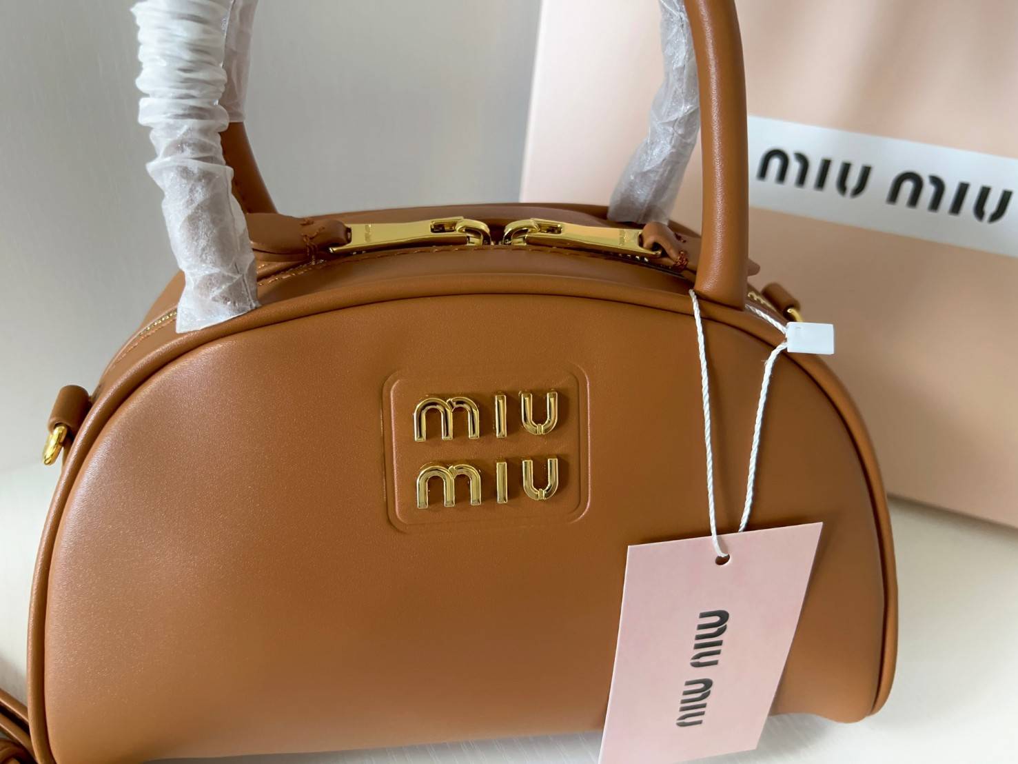 MIU MIU HALF-MOON TOP HANDLE BAG / Patent leather bowling bag / Miu Miu Leather top-handle bag กระเป๋าทรงพระจันทร์เสี้ยว หนังนิ่ม ลื่นเงา ตัดกับอะไหล่ทองได้ลงตัว