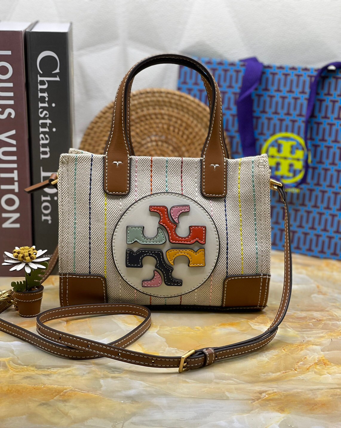 Tory burch ella multi stitch canvas micro tote กระเป๋าใบนี้บอกเลยว่าสไตล์เก๋และแปลกตาเลยทีเดียว กระเป๋าทรงสี่เหลี่ยมขนาดมินิ มีสายเล็กๆ สำหรับสะพายข้าง ลวดลายและสีสันบนกระเป๋ามีเอกลักษณ์ความเป็นวินเทจแบบทอรี่โดยเฉพาะ เป็นอีกหนึ่งแอ็กเซสเซอรี่ที่ทางแบรนด์ร