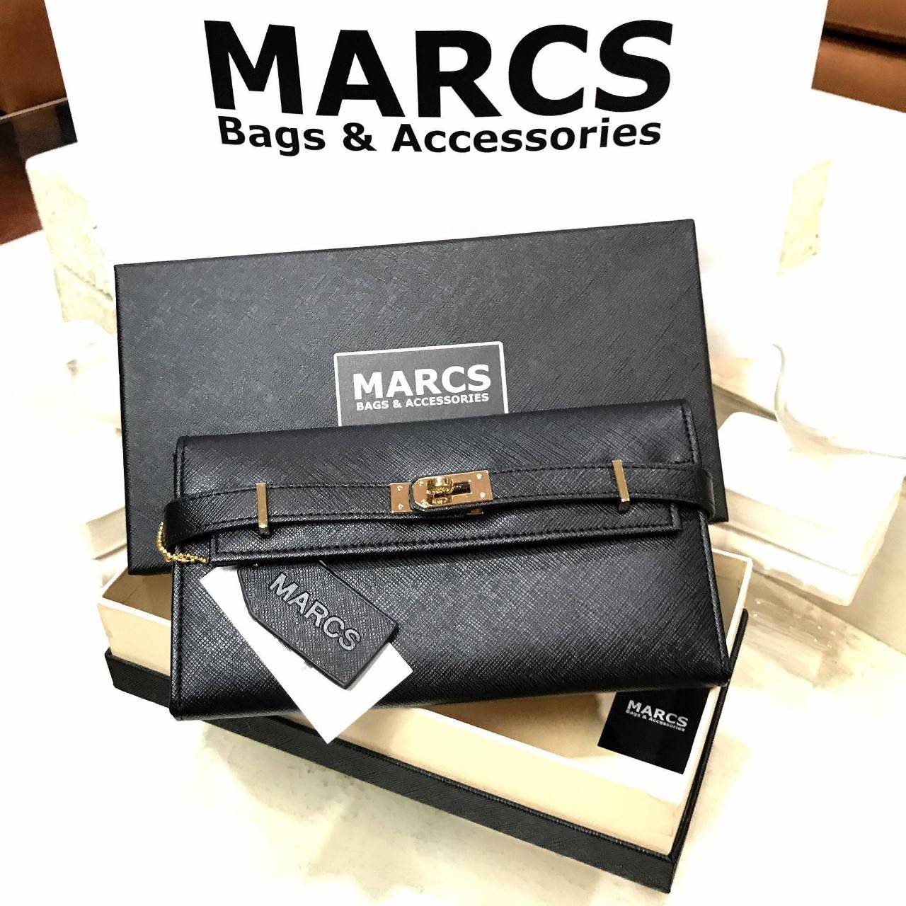 พร้อมส่งความสวย! NEW ARRIVAL! MARCS PADLOCK LONG WALLET กระเป๋าสตางค์ใบยาววัสดุหนัง Saffiano สวยหรูโดดเด่นด้วยสายหนังรัดกระเป๋าด้านหน้าสไตล์ Birkin ภายในมีโลโก้และมีช่องแบ่งหลายช่องเป็นสัดส่วนช่องใส่บัตรหลายช่อง มีช่องซิปสำหรับใส่เหรียญ ใส่ธนบัตร และ ipho