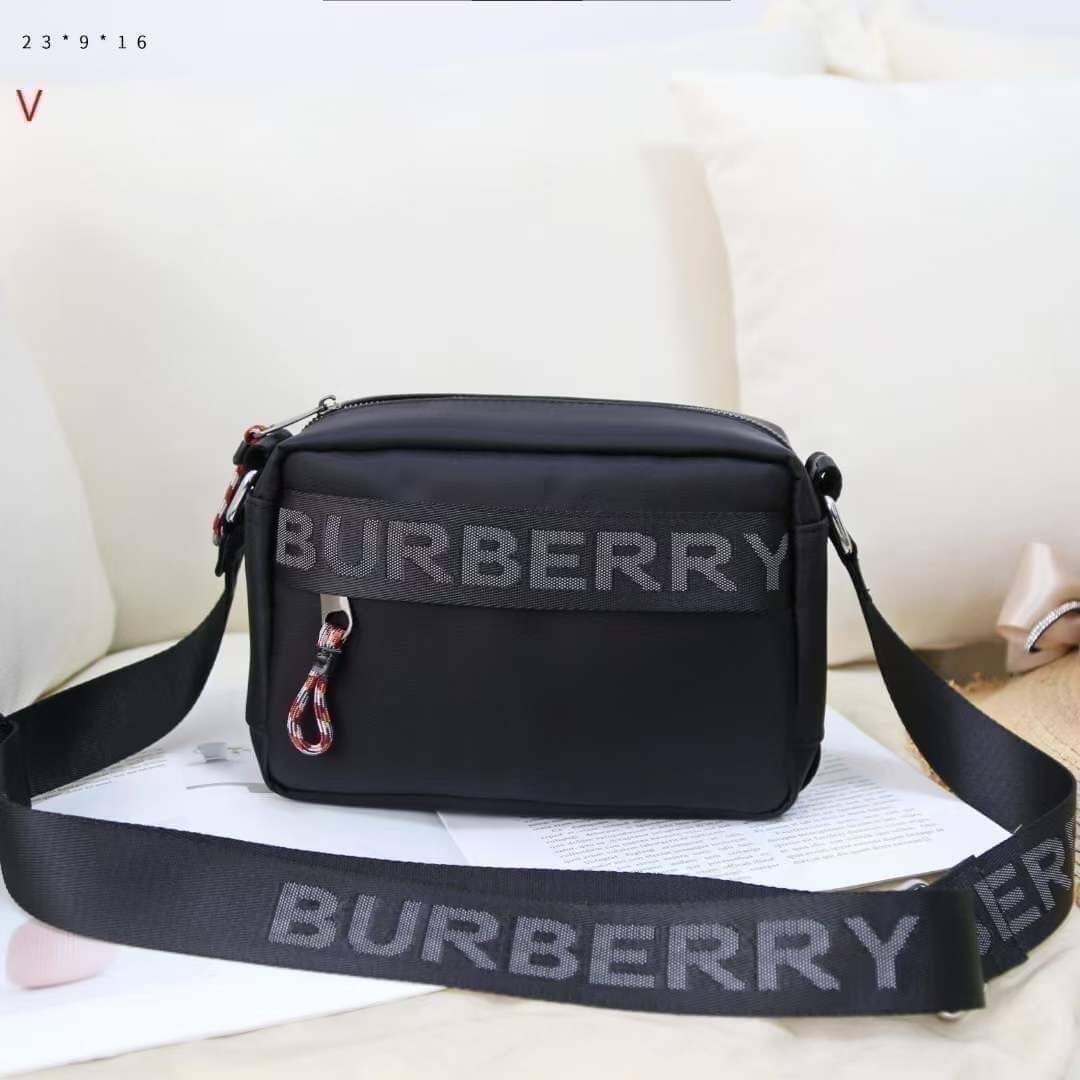 BURBERRY FRAGRANCES CROSSBODY BAG / BURBERRY Nylon Crossbody Bag วัสดุ Nylon Canvas ทรงเหลี่ยมน้ำหนักเบามีโลโก้แบรนด์คาดด้านหน้าพร้อมช่องซิปใส่ของ เปิดปิดด้วยซิปหัวซิปแบรนด์สไตล์สปอร์ต ภายในมีช่องใส่บัตร ขนาดกำลังดีสามารถใส่กล้อง มือถือ กระเป๋าสตางค์ของใช