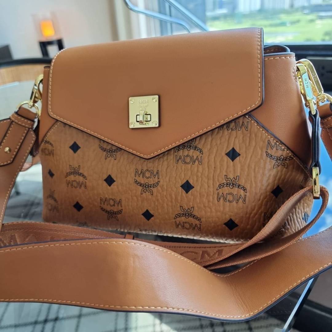 M.C.M ESSENTIAL CROSSBODY IN VISETOS กระเป๋าสะพายข้าง สวยอยู่ทรง ดีไซน์ไม่ซ้ำใคร มาพร้อมสายสะพายถึง 2 แบบ ปรับเปลี่ยนใช้ได้ไม่มีเบื่อ วัสดุหนังแคนวาสสลับหนังแท้ เปิด-ปิดกระเป๋าด้วยตัวบิดล็อคแน่นหนา ด้านหลังมีช่องเก็บบัตรได้ ภายในโล่งกว้าง แบ่งสัดส่วน เป็น