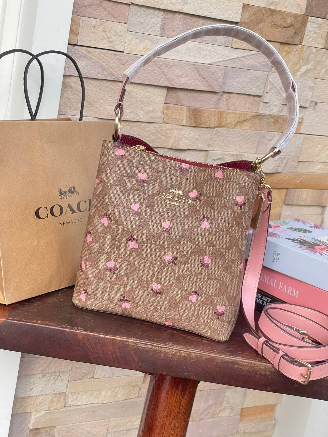 OUTTLET 】COACH SMALL TOWN BUCKET BAG IN SIGNATURE WITH Heart floral print สำหรับสาวแฟชั่นที่ชอบรายละเอียดชิคๆ ดีไซน์สุดเก๋ แนะนำเลยสำหรับกระเป๋าทรงบักเก็ตใบนี้ เชื่อว่าสาว ๆ หลายคนชื่นชอบ เป็นไอเทมที่สามารถแมทช์ได้กับเสื้อหลากหลายสไตล์ บรรจุของได้เยอะโดยท