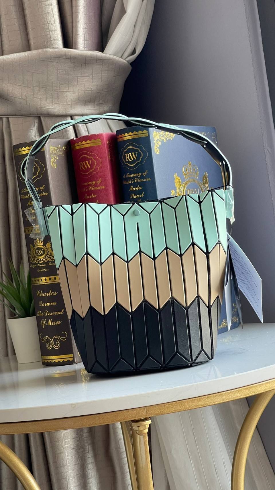 small : BAO BAO ISSEY MIYAKE SMALL BUCKET เป็นกระเป๋าบัคเก็ตขนาดเล็กสามารถใช้ใส่กระเป๋าสตางค์และโทรศัพท์มือถือได้ ซีรีย์ใหม่นี้มีจุดเด่นที่แผ่นรูปทรงสี่เหลี่ยมด้านขนานในแนวตั้ง เกิดเป็นรูปทรงสามมิติ