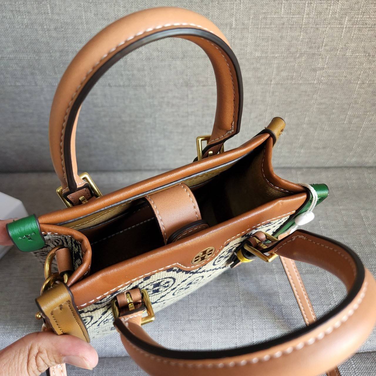 TORY BURCH T MONOGRAM COLORBlOCK JACQUARD MINI TOTE คอลเลคชั่นใหม่ล่าสุด ครอบครองก่อนใคร ไอเท็มยุคนี้รุ่นที่ควรมีติดตู้คะสาวๆ วัสดุ jacquard สลับหนังแท้ หูจับ มาพร้อมสายสะพายข้างหนังแท้ ปรับระดับได้ สายสามารถถอดออกได้ ภายในเป็นช่องโล่ง ใส่มือถือได้ กระเป๋