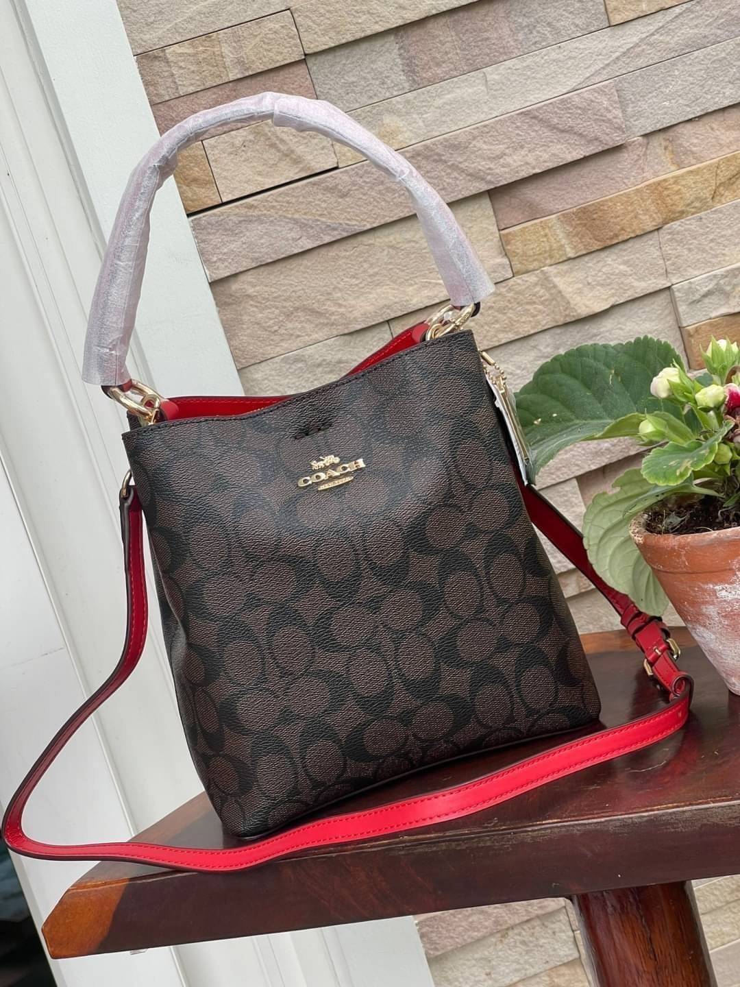 COACH SMALL TOWN BUCKET BAG IN SIGNATURE สำหรับสาวแฟชั่นที่ชอบรายละเอียดชิคๆ ดีไซน์สุดเก๋ แนะนำเลยสำหรับกระเป๋าทรงบักเก็ตใบนี้ เชื่อว่าสาว ๆ หลายคนชื่นชอบ เป็นไอเทมที่สามารถแมทช์ได้กับเสื้อหลากหลายสไตล์ บรรจุของได้เยอะโดยที่กระเป๋าไม่เสียทรง แบ่งช่องใช้งา