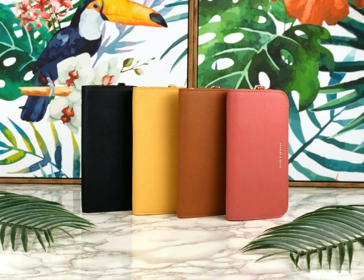 CHARLES & KEITH CLASSIC ZIP AROUND WALLET กระเป๋าเงินใบยาวซิปรอบ มีสายคล้องมีสีเข้ากระเป๋า 1 เส้น ใช้งานง่ายมากๆ คล้องมือก็เก๋ ด้านหน้าปั๊มโลโก้แบรนด์ เปิดปิดด้วยซิปรอบ ที่สายคล้องมือแต่งหมุดสีสวยเด่น ถอดสายได้ จุบัตรได้ 12 ใบ มีช่องซิปใส่เหรียญและช่องใส่