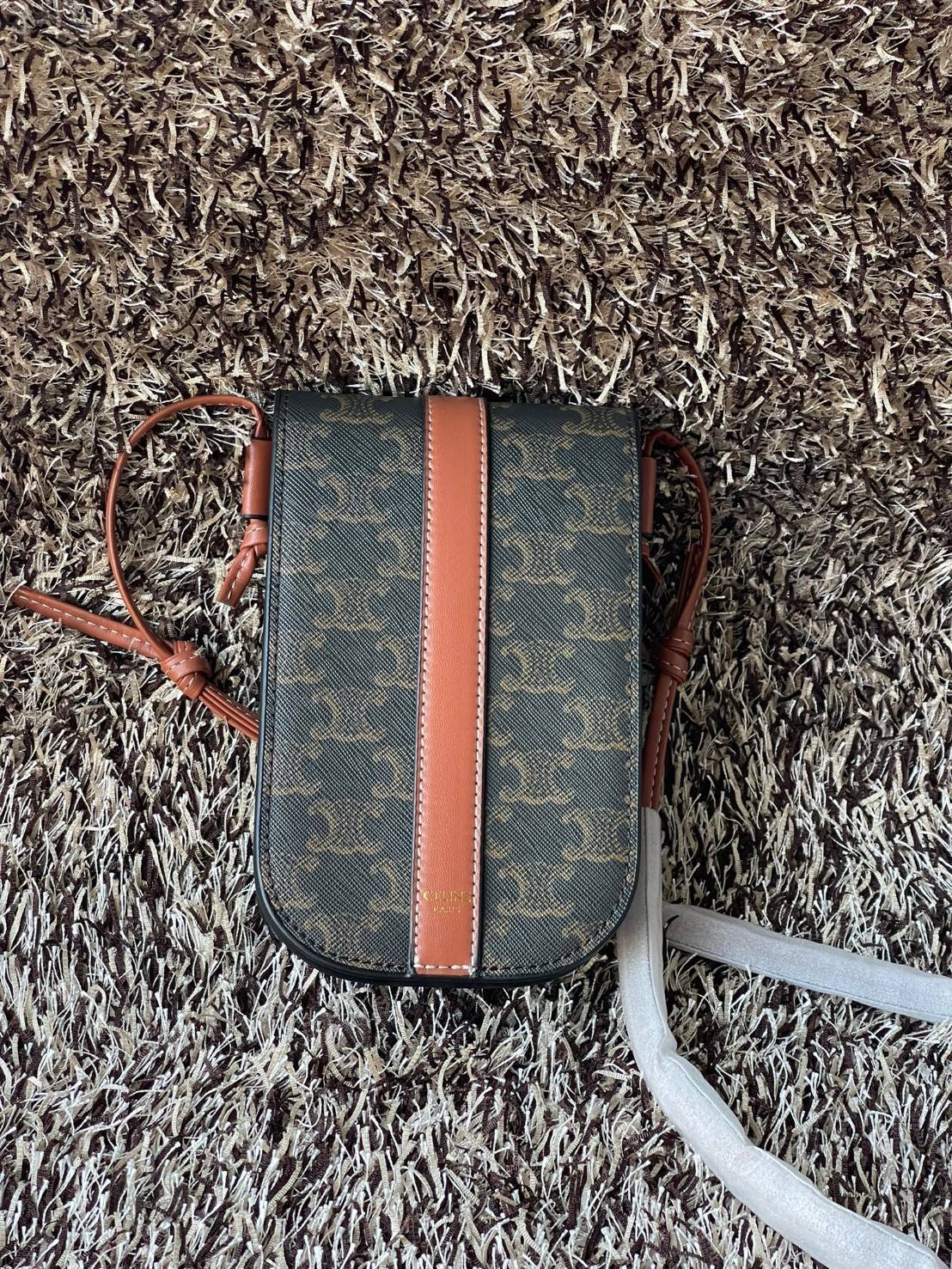 Celine Phone Pouch in Triomphe Canvas กระเป๋าใส่โทรศัพท์รุ่นนี้ มีดีไซน์ดูเรียบง่าย แต่ดูหรูหราด้วยลวดลาย Triompe ที่แสดงถึงความเป็นเอกลักษณ์ของ celine ช่องหลักที่มีความกว้าง สามารถใส่โทรศัพท์มือถือ ธนบัตร บัตรต่าง ๆ และของจุกจิกชิ้นเล็ก ๆ ได้แบบจุใจ หรือ