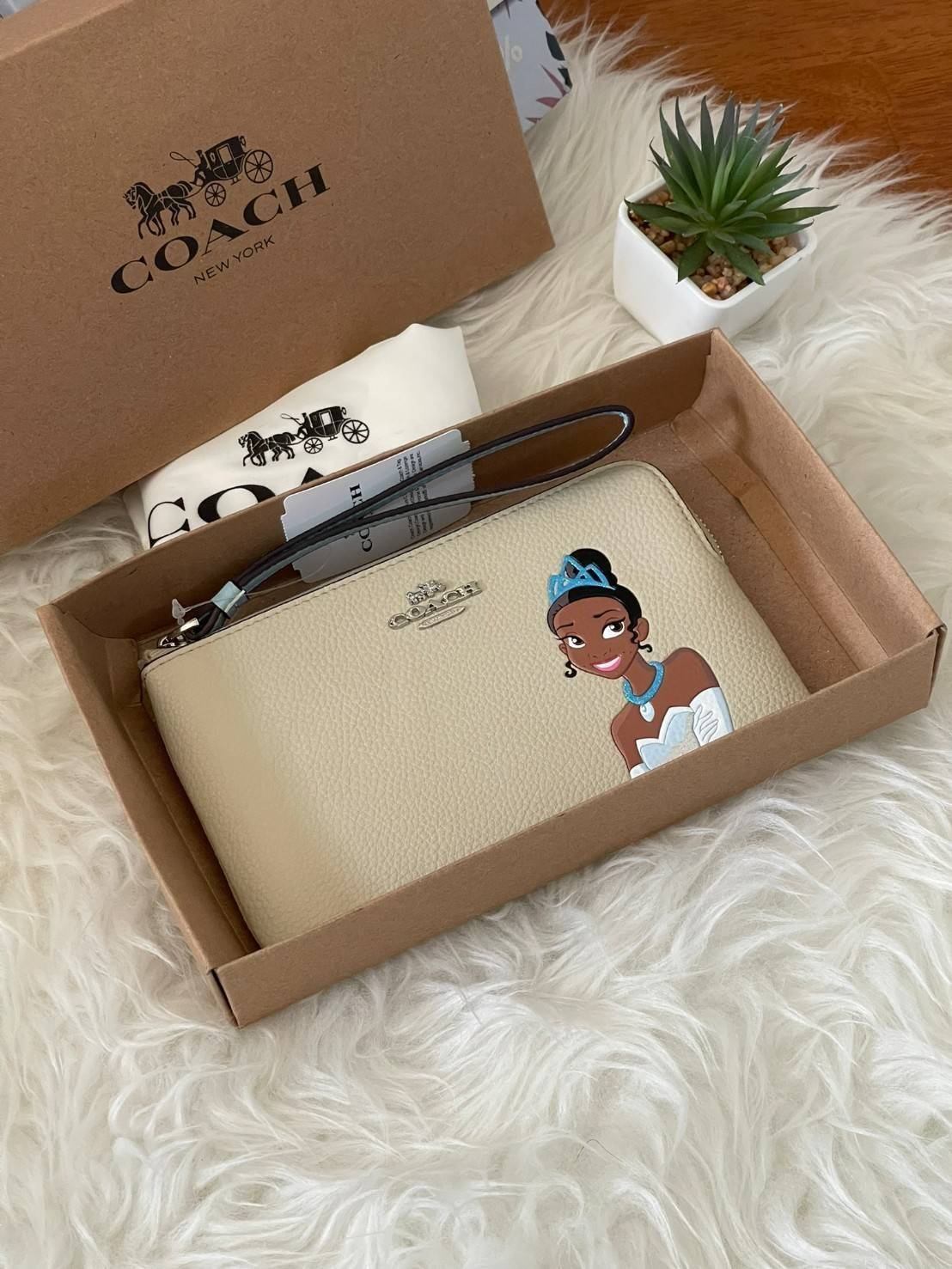 Coach & Disney Corner Zip Wristlet เปิดตัวคอลเลคชั่นเมื่อความดาร์กและโรแมนติกโคจรมาพบกัน เมื่อแบรนด์เครื่องหนังสัญชาติอเมริกัน Coach ร่วมมือกับ Disney สร้างสรรค์คอลเล็กชั่นพิเศษที่ได้รับแรงบันดาลใจมาจากเทพนิยายอเมริกันโกธิกของนิวยอร์ค ถ่ายทอดผ่านเหล่าตัวล