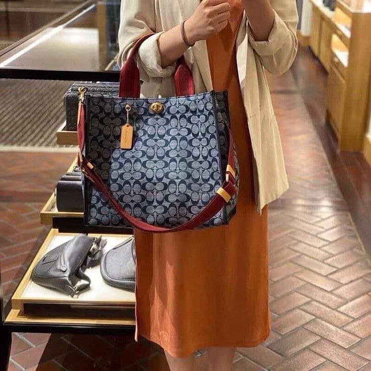 COACH Tote 34 In Signature Chambray หากคุณกำลังมองหากระเป๋าที่มีดีไซน์แปลกตา ไม่ค่อยเหมือนที่พบเห็นทั่วไป ต้องเป็นรุ่นนี้เลยค่ะ นอกจากจะผลิตจากผ้าแชมเบรย์ซึ่งมีน้ำหนักเบาแล้ว ยังให้สีสันคล้ายกับสียีนส์ สายสะพายและหูหิ้วสไตล์สปอร์ต ที่สำคัญยังมีหมุดปิดกระเ