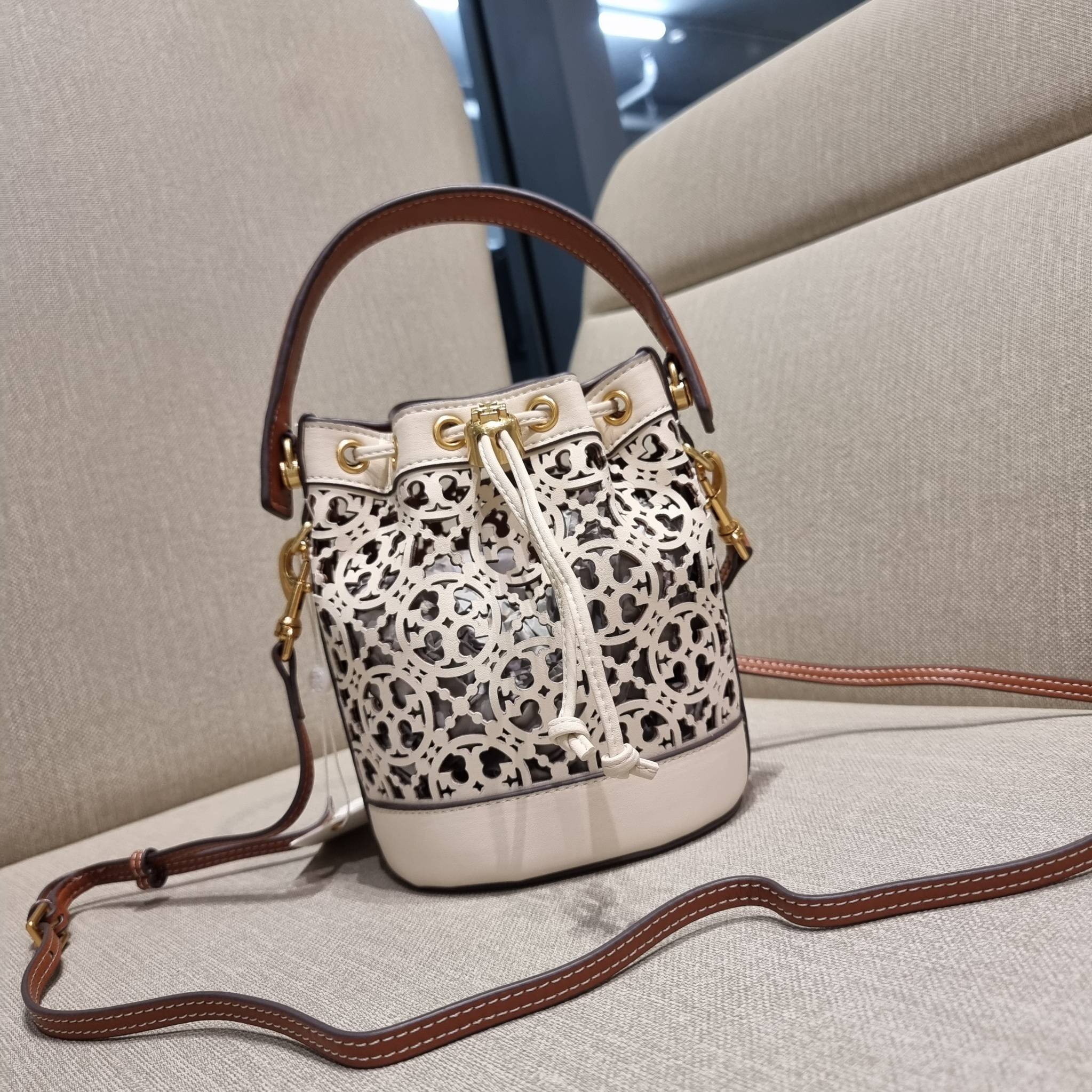 TORY BURCH T MONOGRAM LASER-CUT MINI BUCKET BAG ใจบางที่สุดกับคอลเลคชั่นนี้ กับกระเป๋าสะพายทรงบัคเก็ต ไซส์มินิ รุ่นชูโรงสุดฮิต ที่เพิ่มดีเทลความแพงด้วยการฉลุลวดลายโมโนแกรมรอบใบ ถักทอเป็นเส้นลายสานที่สวยงามมาก งานฝีมือจริงๆ วัสดุหนัง cowhide รูดเปิด-ปิดด้ว