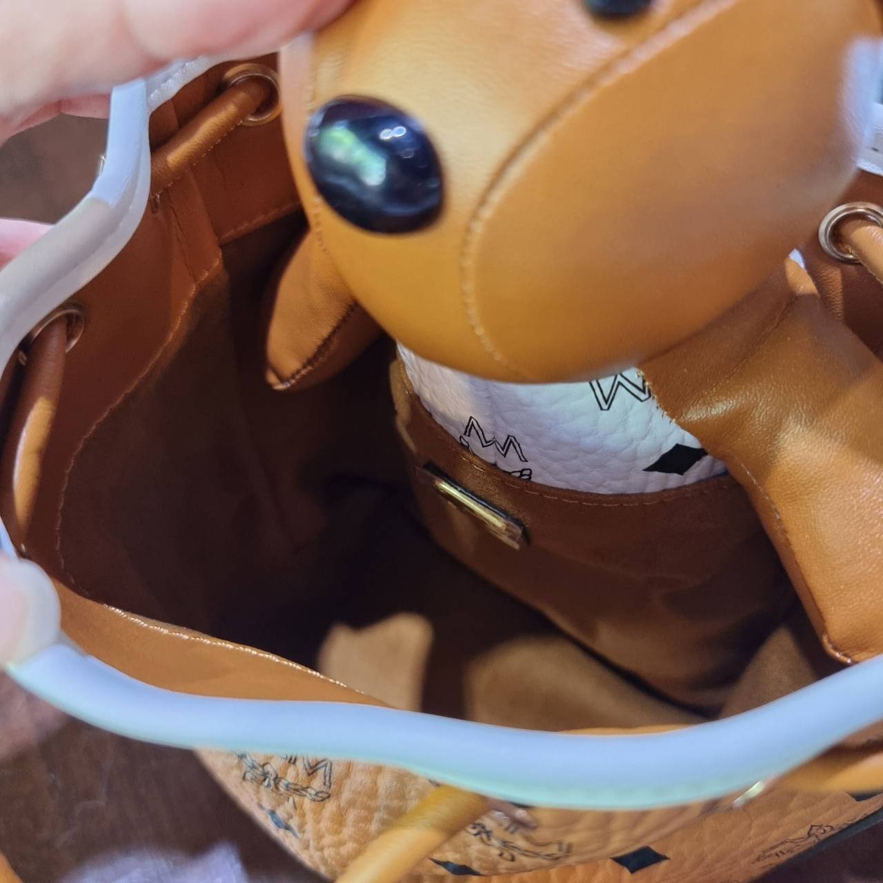 M.C.M ZOO RABBIT DRAWSTRING BAG IN VISETOS LEATHER MIX คอลเลคชั่นซูมาใหม่ ฮิตหนักมากที่เกาหลีและญี่ปุ่น ไอเท็มสุดคิ้วท์ น้องกระะต่ายโดดเด่น กระเป๋าสะพายทรง bucket ไซส์เล็กขนาดน่ารักน่าใช้ แฟชั่นสไตล์มากใบนี้ ดีไซน์น้องกระต่ายแอบในกระเป๋า และสามารถนำออกมาห