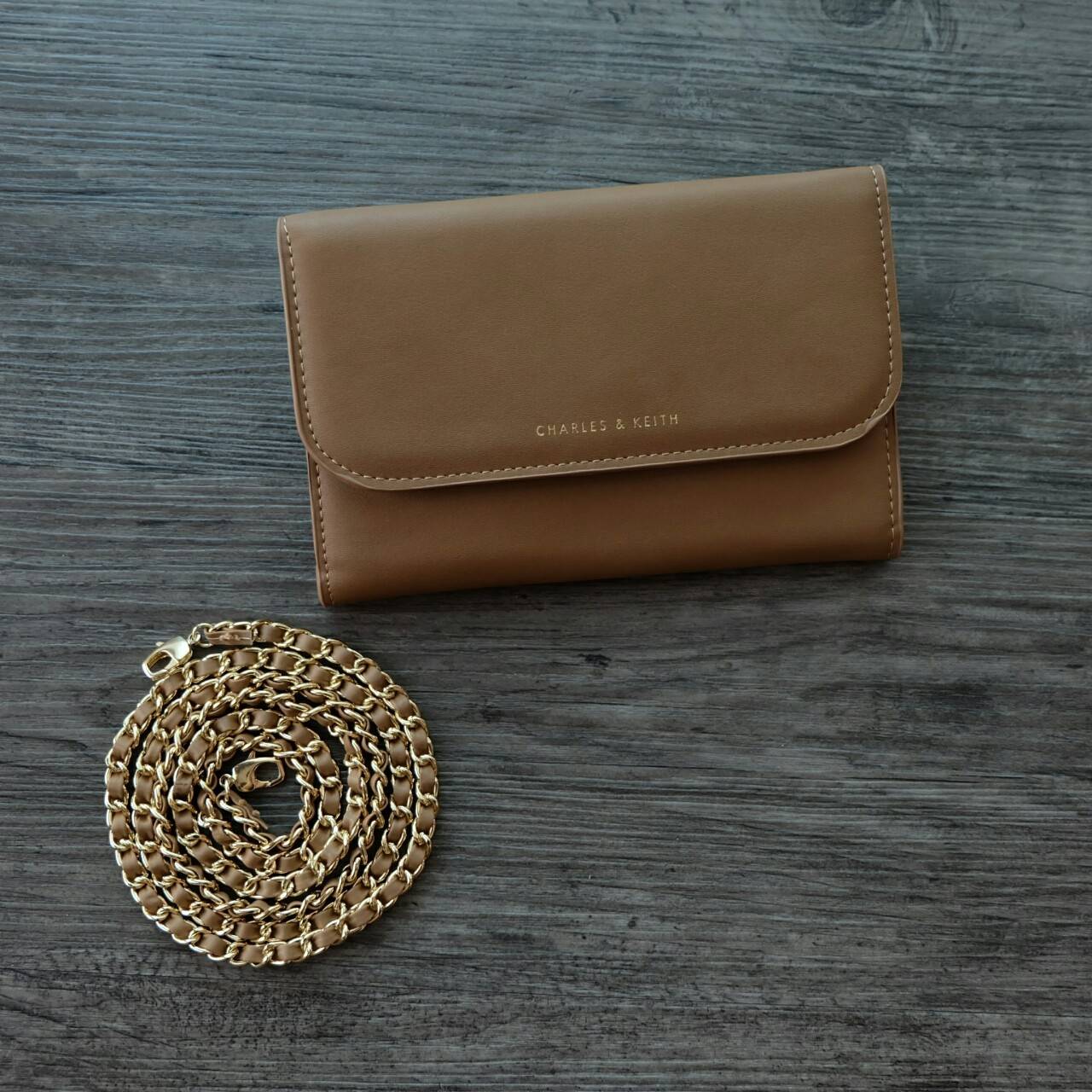 CHARLES&KEITH FRONT FLAP WALLET กระเป๋าสตางค์แบบ cluth คลัช รุ่นชนช็อปเปิดปิดด้วยฝาปิดกระดุมแม่เหล็ก ด้านหน้ามีโลโก้แบรนด์ ภายในมีช่องใส่ของ เยอะค่ะ มีทั้งฝช่องซิป และช่องใส่บัตรหลายช่อง สามารถใส่ธนบัตร มือถือ เหรียญและบัตรได้เยอะ มีกระดุมปรับขยายทรง มาพร