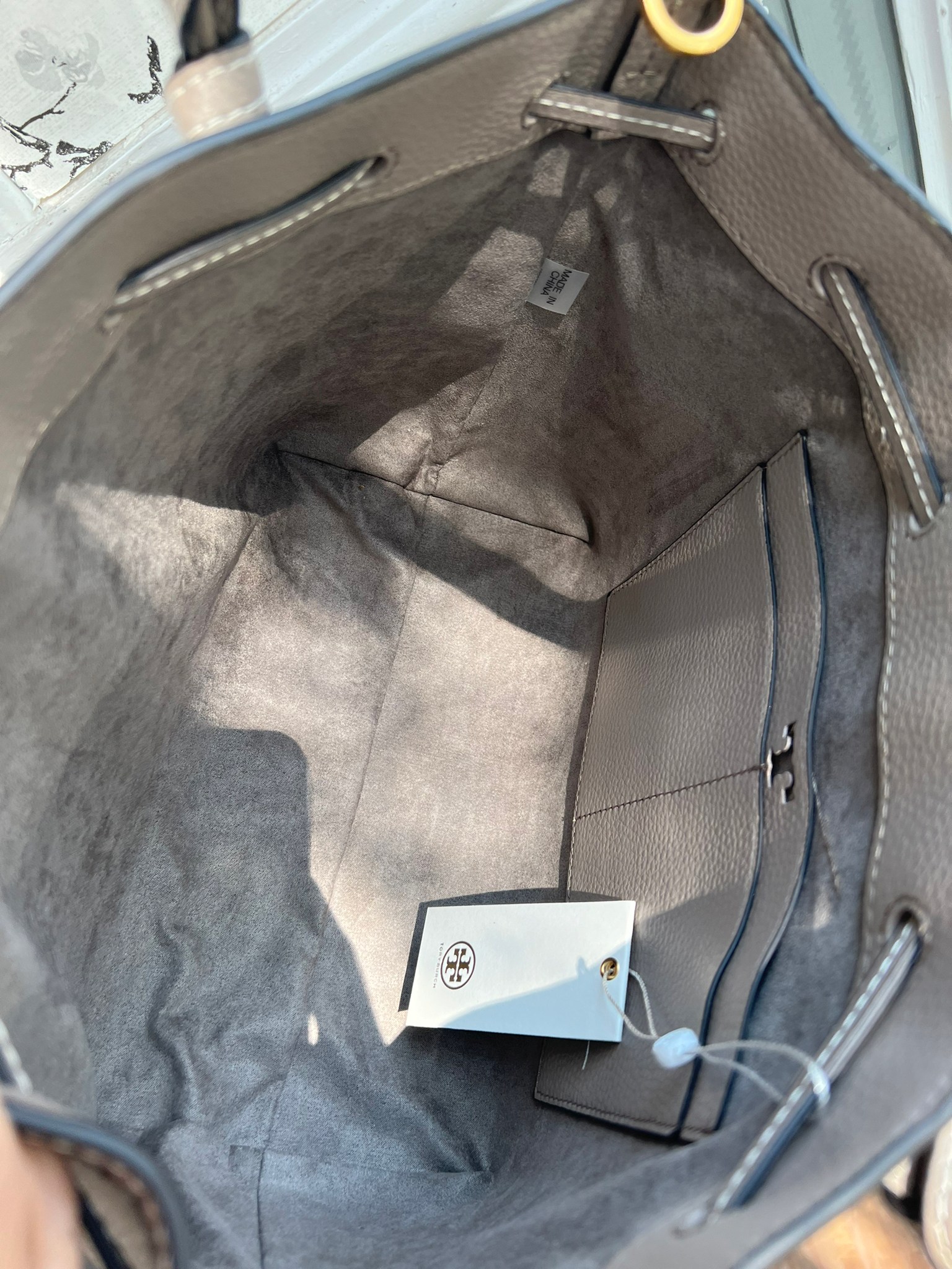 OUTLET 】TORY MCGRAW SMALL DRAWSTRING กระเป๋าถือหรือสะพายข้าง วัสดุหนังวัวแท้ อะไหล่ทอง เปิด-ปิดด้วยสายหนังรูด จะถือหรือสะพายข้างได้Crossbodyได้ น้ำหนักเบาจุของได้เยอะ ด้านหน้าประดับโลโก้แบรนด์ ด้านในมีช่องเล็กสำหรับใส่บัตรใส่ตังค์ได้ มีสายยาว ปรับสายได้ ถ