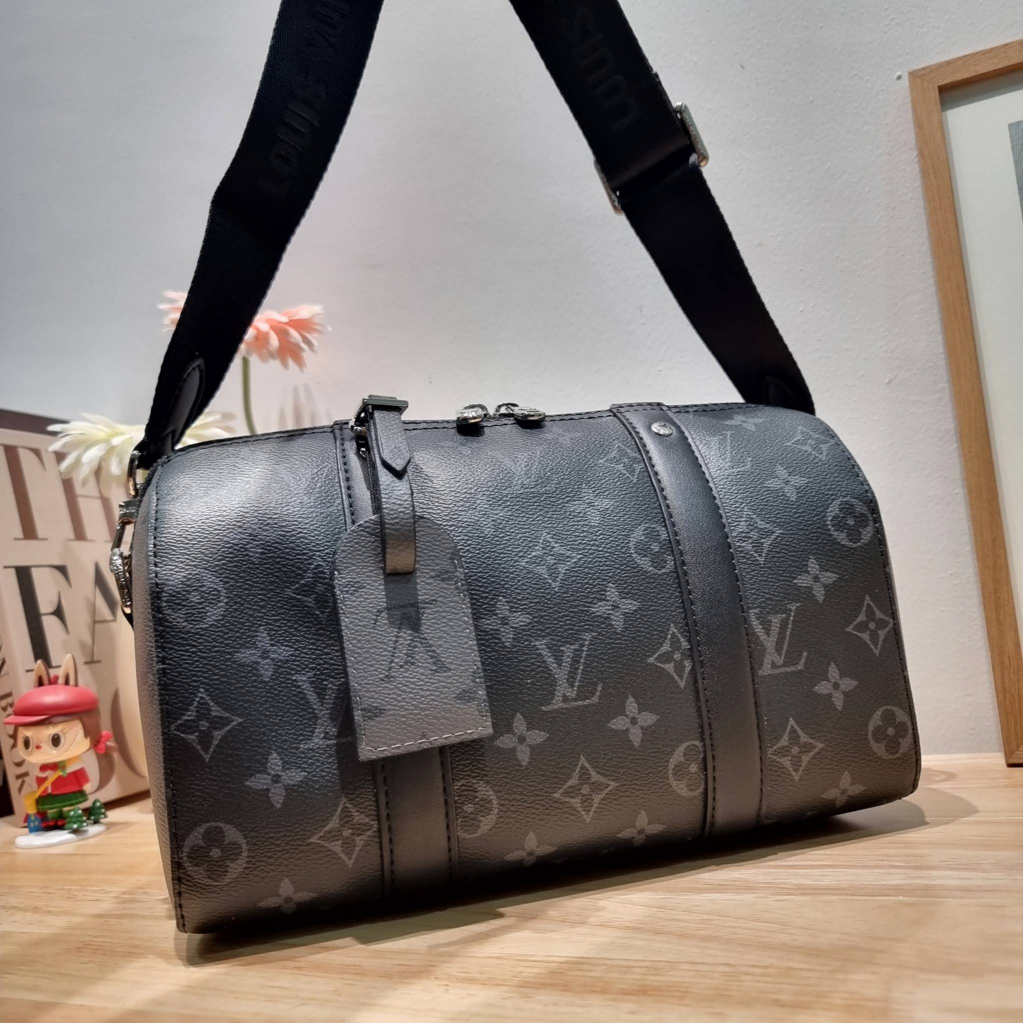 LV CITY KEEPALL Monogram Eclipse Bag กระเป๋าสะพายทรงหมอนสุดคลาสสิค ด้วยดีเทลความเป็นเอกลักษณ์ เรียบหรูด้วยความโดดเด่นจากลวดลายโมโนแกรม ขนาดกำลังดี
