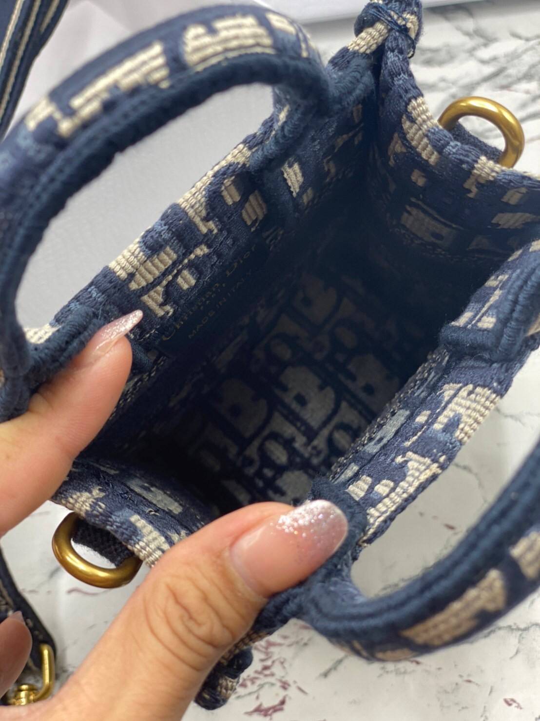 ORI 】Mini Dior Book Tote Phone Bag Blue Dior Oblique Embroidery พร้อมส่งที่ไทย ภาพสินค้าถ่ายจากงานขายจริง ใช้งานต่างประเทศได้ กระเป๋าใบมินิจะใส่โทรศัพท์ได้เช่นเดียวกับของใช้จำเป็นเล็กๆ น้อยๆ ในแต่ละวัน มาพร้อมสายสะพายไหล่แบบปักที่ปรับได้และถอดออกได้ อุปกร