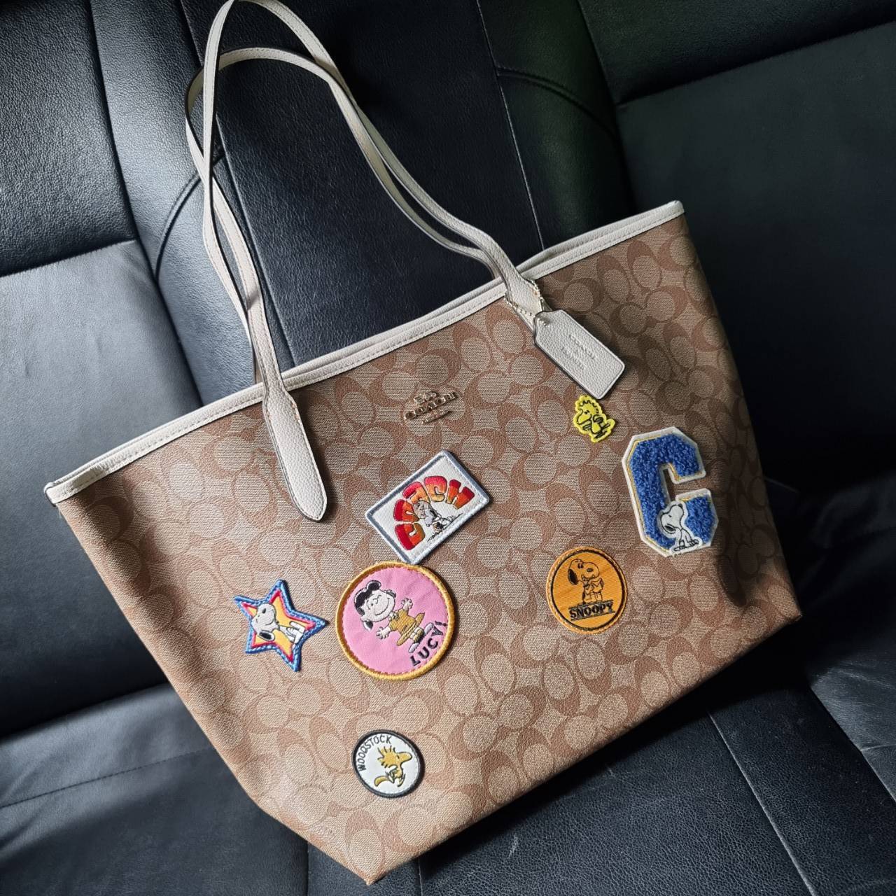 COACH C4292 COACHxPEANUTS CITY TOTE IN SIGNATURE CANVAS WITH VARSITY PATCHES กระเป๋าทรงโท้ทใบใหญ่ กับคอลเลคชั่นคอลแลบใหม่ล่าสุด น่ารักด้วยเหล่าผองเพื่อนสนู้ปพี สวยโดดเด่นมากๆ ใบนี้ใส่ของได้ของครบครัน จุได้แบบไม่ต้องกลัวเต็ม!! วัสดุหนังแคนวาสคุณภาพดี ปากกร