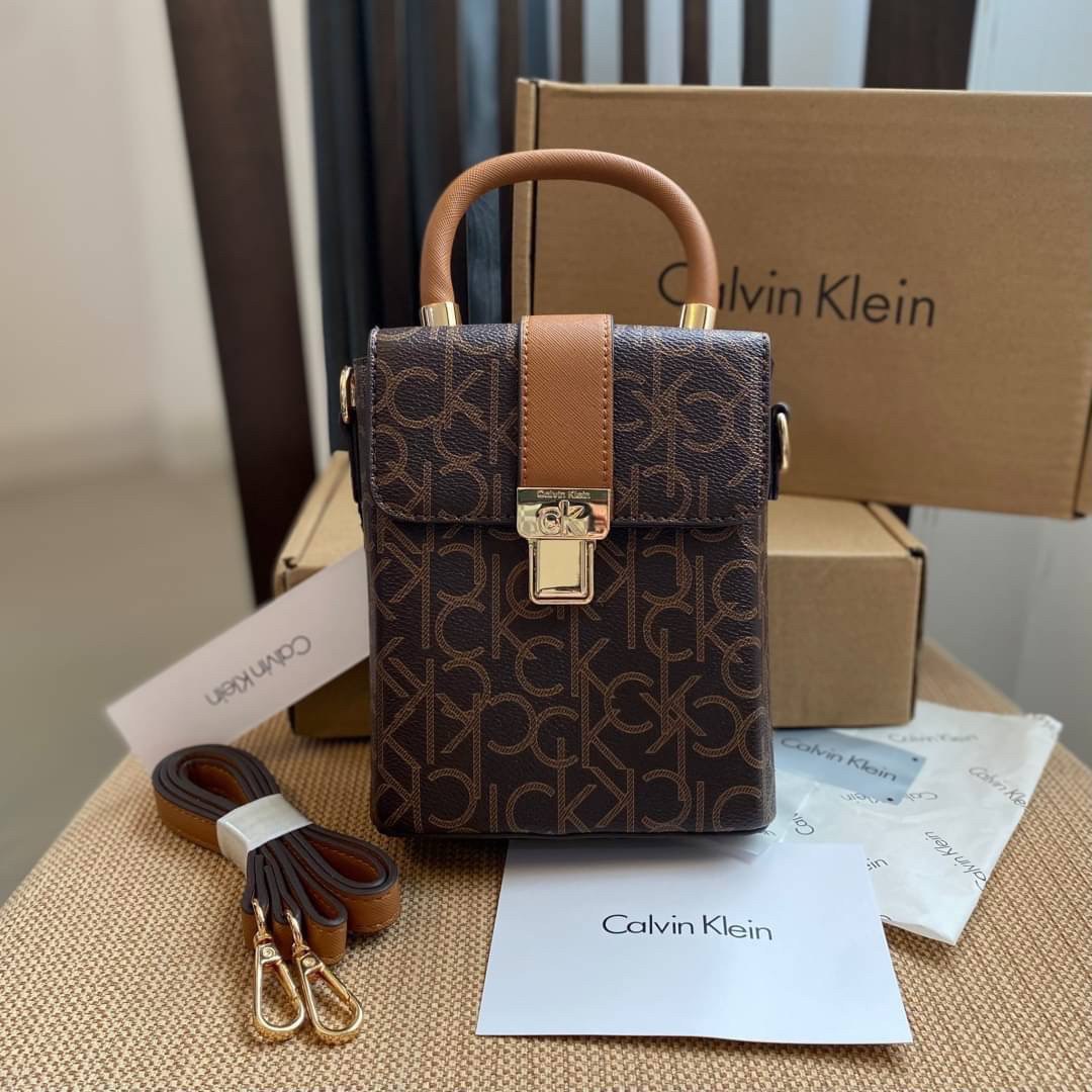 CALVIN KLEIN JEANS crossbody bag กระเป๋าถือหรือสะพาย ลายซิกเนเจอร์แบรนด์ทั้งใบ มีหูจับสำหรับถือ เปิด-ปิดกระเป๋าด้วยกระดุมแม่เหล็ก ด้านในโล่งกว้างมีช่องเล็กและช่องซิปสำหรับใส่ของจุกจิก ซับในลายแบรนด์อย่างดี มาพร้อมสายสะพายยาวปรับระดับได้ สามารถใช้ได้หลากหล