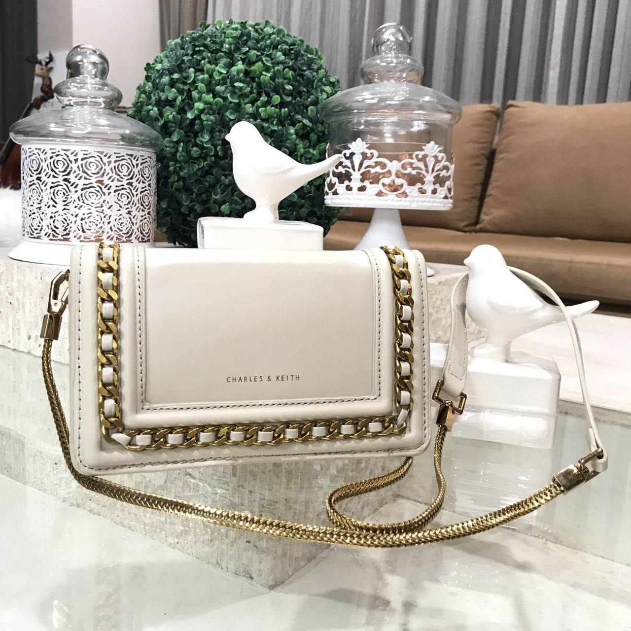 NEW ARRIVAL! CHARLES & KEITH CHAIN DETAIL CROSSBODY BAG กระเป๋าสะพายทรงสี่เหลี่ยมรุ่นชนช็อปขนาดกำลังดีวัสดุหนังนิ่มเรียบประดับด้วยโซ่ด้านหน้าดูมีดีเทล เปิดปิดด้วยกระดุมแม่เหล็ก ภายในมีช่องใส่บัตรและช่องซิป มาพร้อมสายโซ่ต่อหนังถอดถือเป็นคลัชได้ ภาพถ่ายสินค