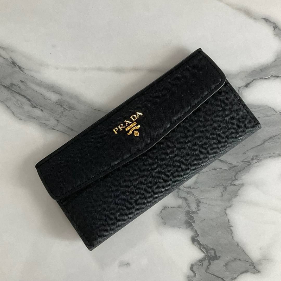PRADA LONG WALLET Best Seller กระเป๋าสตางค์รับทรัพย์ ทรงหรู ลายหนัง SAFFIANO มีช่องใส่บัตร ถึง 12 ช่อง และช่องซิปใส่ของจุกจิกได้ น้ำหนักเบา จับถนัดมือ ขนาดกำลังดี