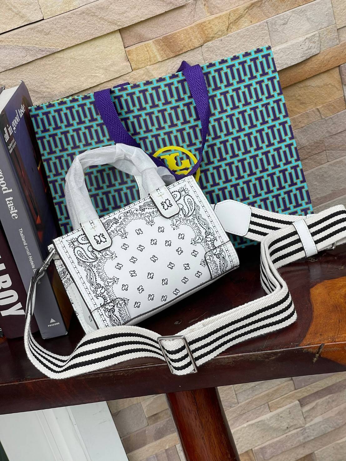 Tory Burch Ella Printed Leather Micro Tote Bag กระเป๋าขนาดมินิใบนี้บอกเลยว่าสไตล์เก๋และแปลกตาเลยทีเดียว กระเป๋าทรงสี่เหลี่ยมขนาดมินิ มีสายสะพายที่ออกแบบมาเข้ากับกระเป๋าสำหรับสะพายข้าง ลวดลายและสีสันบนกระเป๋ามีเอกลักษณ์ที่แสดงถึงความเป็นศิลปะแบบทอรี่โดยเฉพ