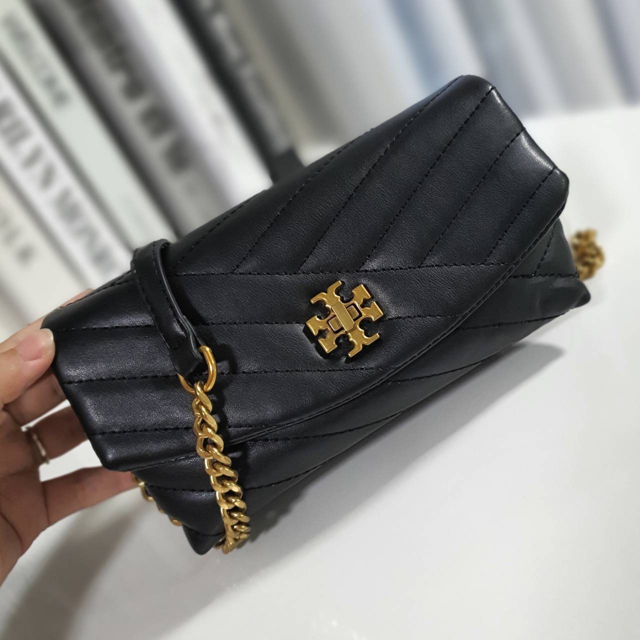 Tory Burch Kira Crossbody Bag กระเป๋าสะพายข้างทรงสวย ใบขนาดเล็กกำลังดี วัสดุหนังสังเคราะห์ นิ่มมือมากกก **อะไหล่ทองวินเทจ ประดับโลโก้แบรนด์เป็นตัวล็อคด้านหน้า ด้านในบุผ้าไนลอนปั้มแบรนด์ แบ่งช่องเป็นสัดส่วน พร้อมช่องซิปกลาง สามารถใส่กระเป๋าสตางค์ใบกลาง มือ