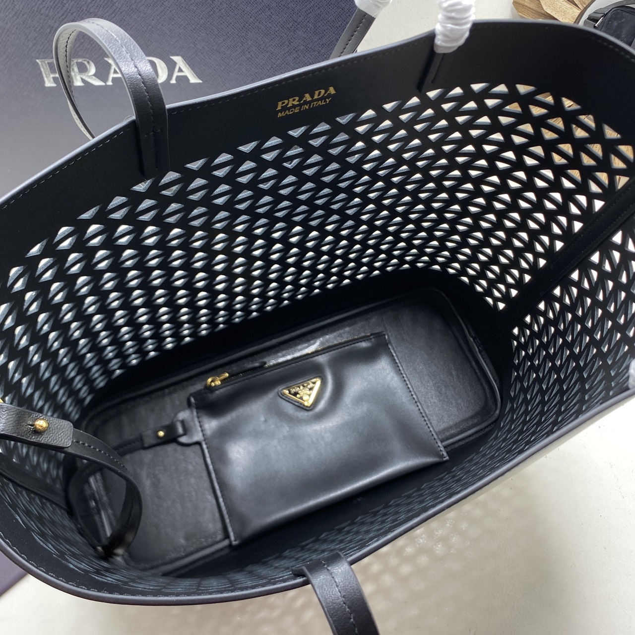 TOP ORI หนังแท้ | Prada Large perforated leather tote bag กระเป๋าทรงโท้ทใบใหญ่ ใจบางที่สุดกับคอลเลคชั่นนี้ ที่เพิ่มดีเทลความแพงด้วยการฉลุลวดลายรอบใบ ถักทอเป็นเส้นลายสานที่สวยงามมาก งานฝีมือจริงๆ