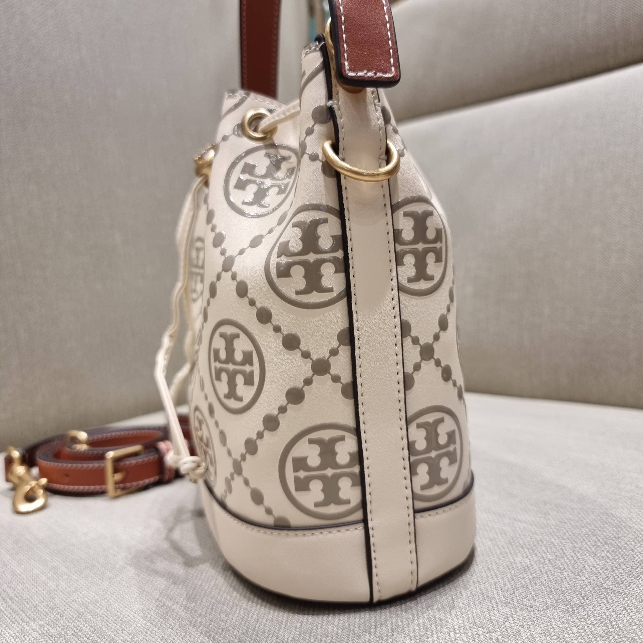 TORY BURCH T MONOGRAM EMBOSSED BUCKET BAG คอลเลคชั่นใหม่ กับกระเป๋าบัคเก็ตทรงยอดนิยม ดีไซน์ใหม่ล่าสุด สวยลูกคุณหนู หรูหรา!! ด้วยดีเทลผิวลายนูนลวดลายเอกลักษณ์ วัสดุหนังแท้ ปากกระเป๋ารูดเปิด-ปิดได้ มีหูจับในตัว สะดวกใช้ไปอีก และมีสายสะพายข้าง ปรับได้อีกด้วย