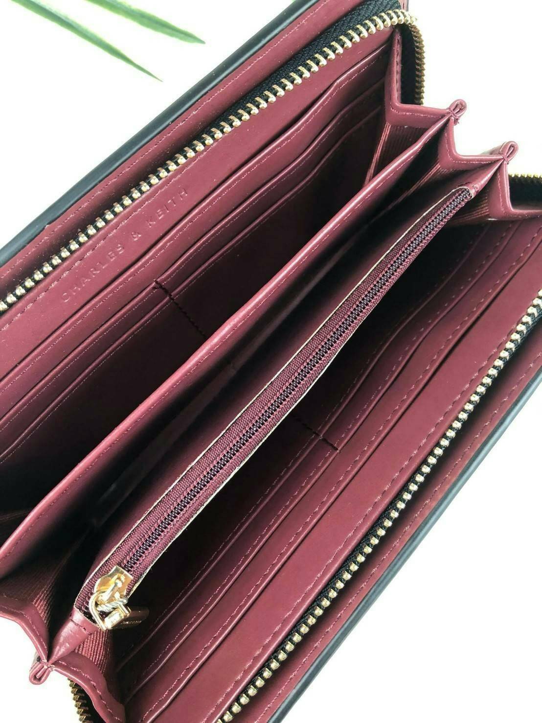 CHARLES & KEITH CLASSIC ZIP AROUND WALLET กระเป๋าเงินใบยาวซิปรอบ มีสายคล้องมีสีเข้ากระเป๋า 1 เส้น ใช้งานง่ายมากๆ คล้องมือก็เก๋ ด้านหน้าปั๊มโลโก้แบรนด์ เปิดปิดด้วยซิปรอบ ที่สายคล้องมือแต่งหมุดสีสวยเด่น ถอดสายได้ จุบัตรได้ 12 ใบ มีช่องซิปใส่เหรียญและช่องใส่