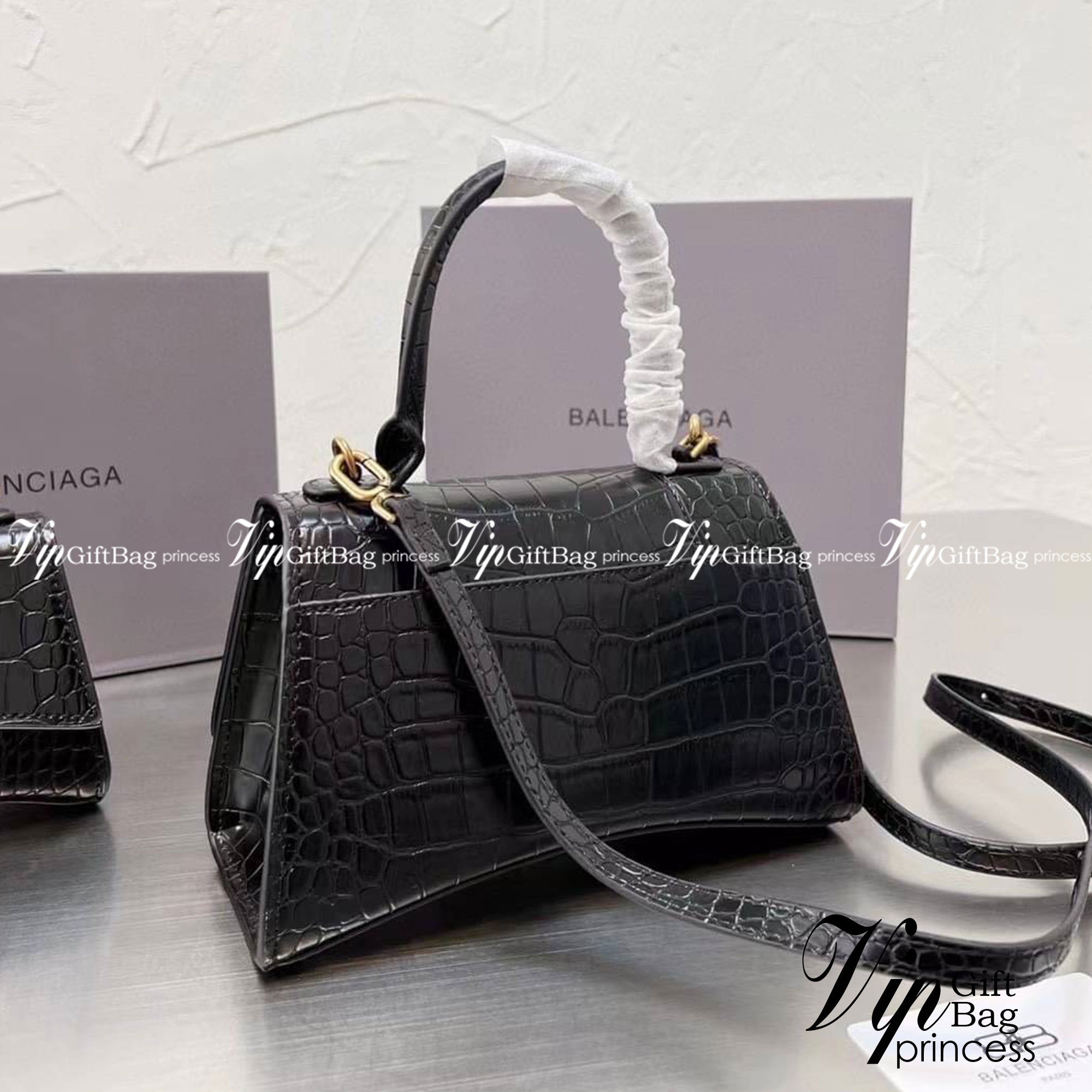 BALENCIAGA Hourglass BAG XS S / BALENCIAGA Hourglass Crocodile embossed calfskin กระเป๋าสะพายแบรนด์หรูซิกเนเจอร์ใบล่าสุด ที่มาพร้อมดีไซน์โดดเด่น มีความโฉบเฉี่ยว โค้งมนเหมือนพระจันทร์เสี้ยว เพิ่มความโดดเด่นสะดุดตาด้วยการตกแต่งอักษร B เมทัลลิก ที่เป็นเอกลัก