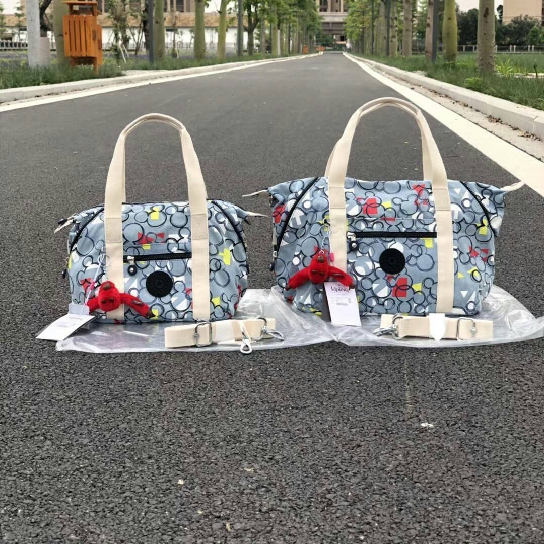 Kipling D ART MINI Collection Mickey กระเป๋าถืออเนกประสงค์ Art Mini จาก KIPLING ขนาดเล็กมีน้ำหนักเบา และช่องกระเป๋ากว้าง สะดวกในทุกการพกพาไปพร้อมคุณ มีมุมด้านข้างสามารถปรับได้ให้เข้ากับการใช้งานของคุณ โดยการรูดซิปลงเพื่อให้เป็นกระเป็นกระเป๋าสะพายดีไซน์เก๋
