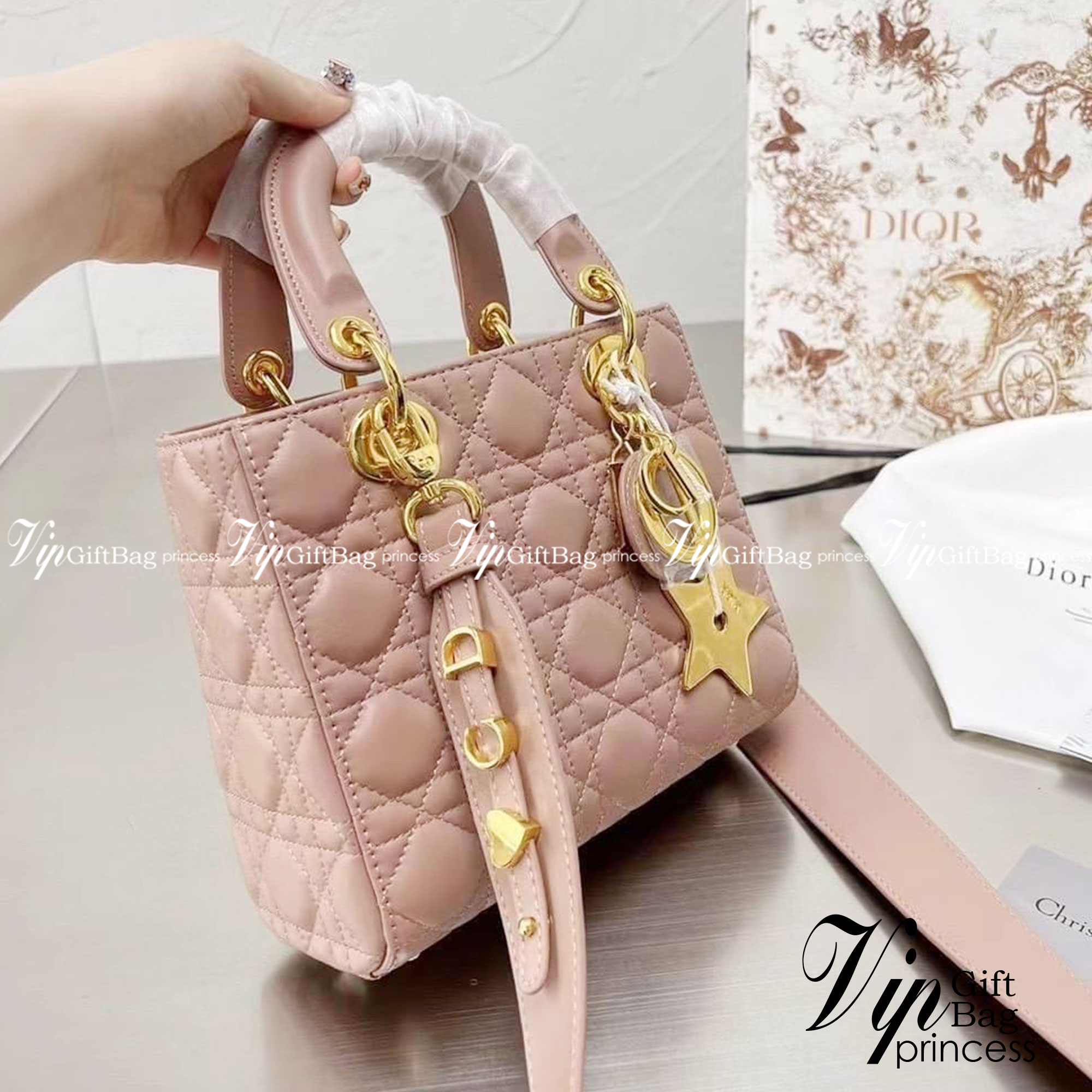 DIOR Lady / Small Lady Dior Bag Cannage Lambskin กระเป๋าสุดไอคอนิก รูปทรงสีเหลียม ขนาดกระทัดรัด ตั้งอยู่ทรง ฐานกระเป๋าแข็งแรง มีหมุดรองฐาน ดีไซน์เอกลักษณ์เฉพาะตัว ด้านหน้าตกแต่งด้วยตัวอักษร D.I.R ห้อยเป็นพวงกุญแจ จะถือหรือสะพายไหล่ก็ดูดีมากๆ ค่ะ