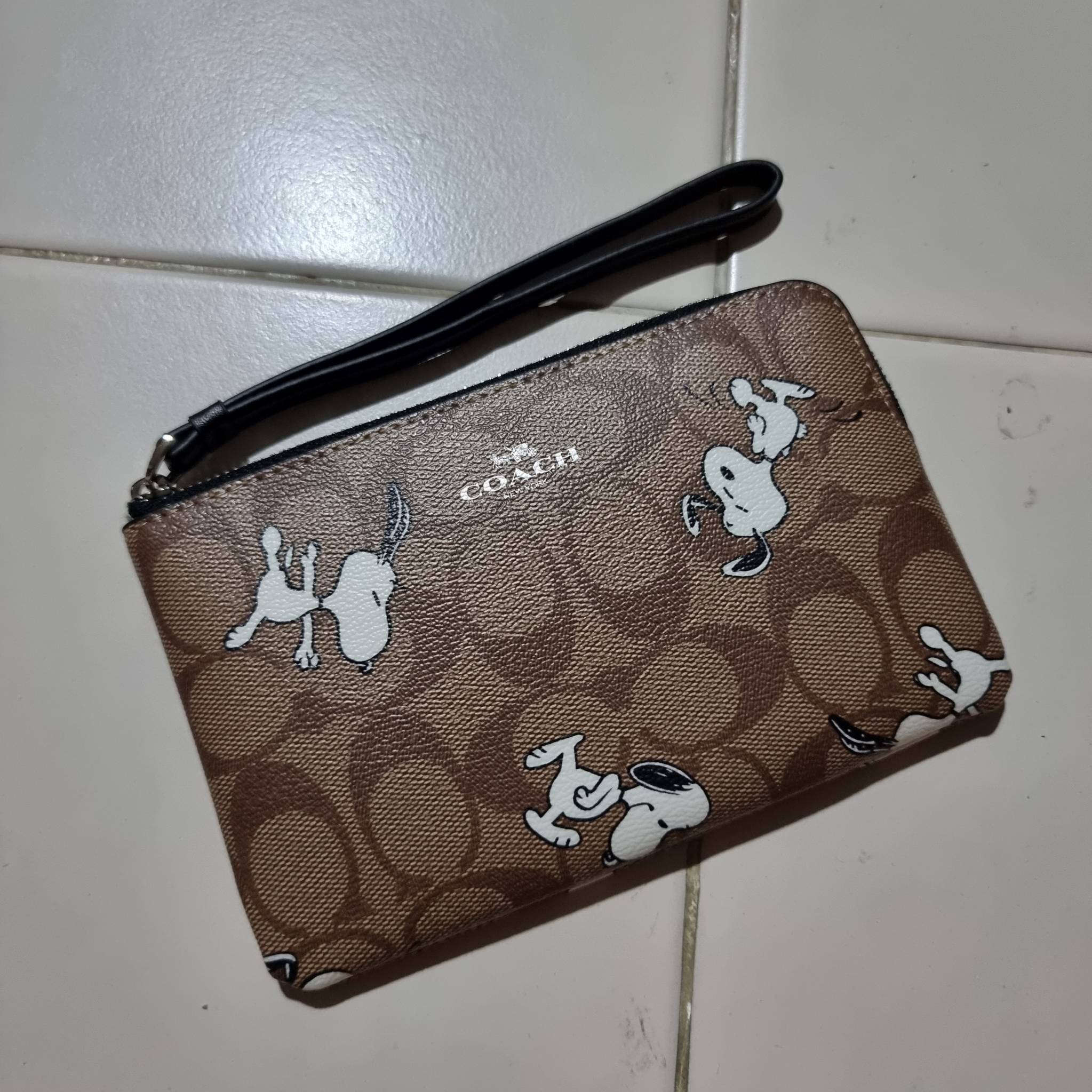 COACH C4589 COACH x PEANUTS CORNER ZIP WRISTLET IN SIGNATURE CANVAS WITH SNOOPY PRINT เหล่าผองเพื่อนและสนูปพีมาแล้วจ้า คอลเลคชั่นสุดน่ารักที่ฮอตไม่มีตก กระเป๋าคล้องมือ ขนาดเหมาะพกพากำลังเหมาะ วัสดุหนังแคนวาสเคลือบลาย ภายในเป็นช่องโล่ง ใส่ธนบัตร หรือใส่บัต