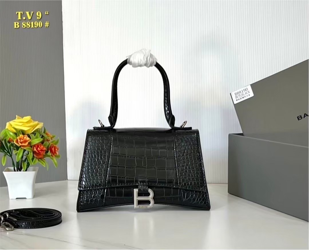 BALENCIAGA Hourglass top-handle tote bag กระเป๋าสะพายแบรนด์หรูซิกเนเจอร์ ที่มาพร้อมดีไซน์โดดเด่น มีความโฉบเฉี่ยว โค้งมนเหมือนพระจันทร์เสี้ยว เพิ่มความสวยสะดุดตาด้วยการตกแต่งอักษร B เมทัลลิก