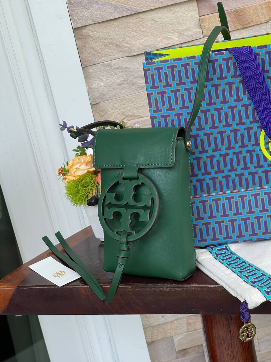 TORY BURCH MILLER METAL PHONE CROSSBODY อีกหนึ่งกระเป๋าใส่มือถือรุ่นฮิตที่เชื่อว่าหลาย ๆ คนต้องเคยเห็นผ่าน ๆ ตามาอย่างแน่นอน กับแบรนด์ Tory Burch ดีไซน์กระเป๋าทรงฝาพับแม่เหล็กใช้งานง่าย มาพร้อมดีเทล Logo สีเดียวกับเฉดสีของกระเป๋า แต่ยังมีความน่ารักด้วยทรง