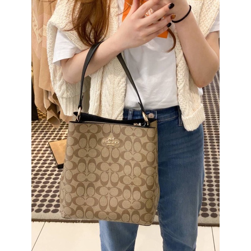 COACH 2312 SMALL TOWN BUCKET BAG IN SIGNATURE CANVAS รุ่นยอดนิยมใบเล็กมาครบสีแล้วจ้า กระเป๋าทรงบัคเก็ต สีผู้ดี๊ผู้ดี ตัวกระเป๋าดีไซน์คลาสสิคลายซี ดูโดดเด่น วัสดุหนังแคนวาสเคลือบลาย สวยคมทุกมุมจริงๆ!! เปิด-ปิดด้วยกระดุมแม่เหล็กทั้ง 2 ฝั่ง ภายในเป็นช่องโล่ง