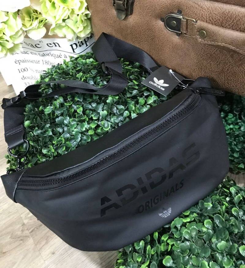Adidas Waist Bag กระเป๋าสะพายสไตล์สปอร์ตแบบคาดเอวหรือคาดอกดีไซน์สุดฮิตใช้ได้ทั้งชายและหญิง วัสดุไนล่อนเนื้อแมทแบบนิ่มด้านหลังเป็นหนังเรียบ กันน้ำทำความสะอาดง่าย ขนาดกำลังดี น้ำหนักเบา ด้านหน้ามีโลโก้แบรนด์ เปิดปิดด้วยซิปสะดวกใช้ หัวซิปแบรนด์ สายสะพายเลื่อ