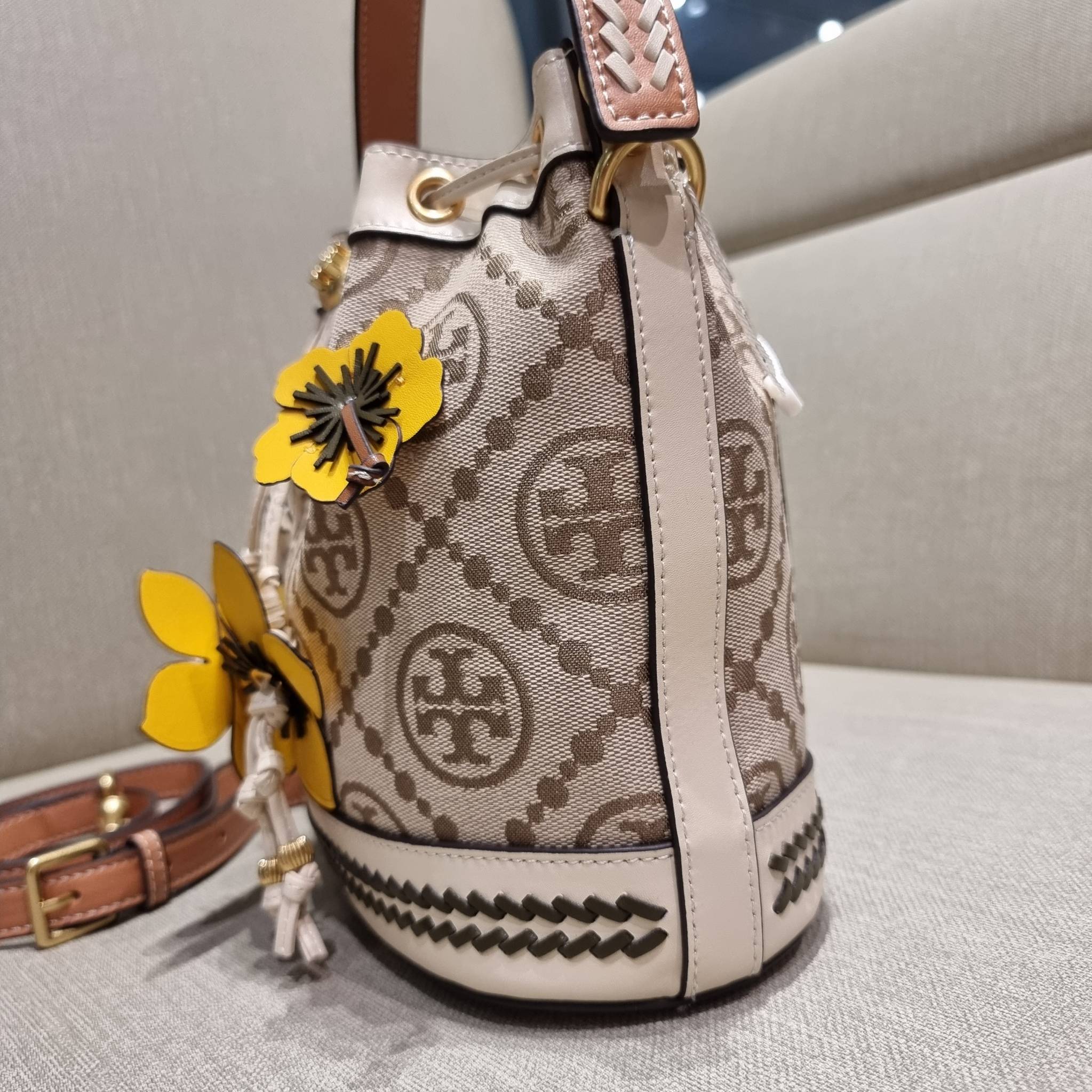 TORY BURCH T MONOGRAM FLORAL BUCKET BAG คอลเลคชั่นใหม่ พร้อมเสิร์ฟความสวยให้ถึงบ้าน!! กระเป๋าบัคเก็ตทรงยอดนิยม ดีไซน์ใหม่ล่าสุด สไตล์งานคราฟ มีลูกเล่นประดับดอกไม้กับตัวกระเป๋า และตัวรูดสาย วัสดุผ้า jacquard ตัดสลับหนังแท้ หูจับและขอบกระเป๋าตกแต่งลายสานสวย