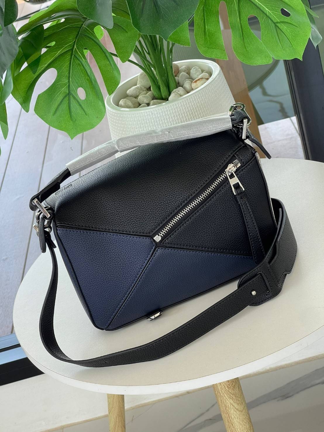 Loewe Puzzle Bag In Classic กระเป๋าทรง Puzzle นี้ออกแบบโดย Jonathan Anderson โดยได้รับแรงบันดาลใจในการออกแบบมาจากรูปทรงของลูกรักบี้ ดังนั้น จึงจะเห็นได้ว่าการตัดเย็บและรูปทรงของกระเป๋านั้นคล้ายคลึงกับลูกรักบี้ รูปทรงดูมินิมอลไม่ทิ้งคอนเซ็ปต์ของแบรนด์ สามา