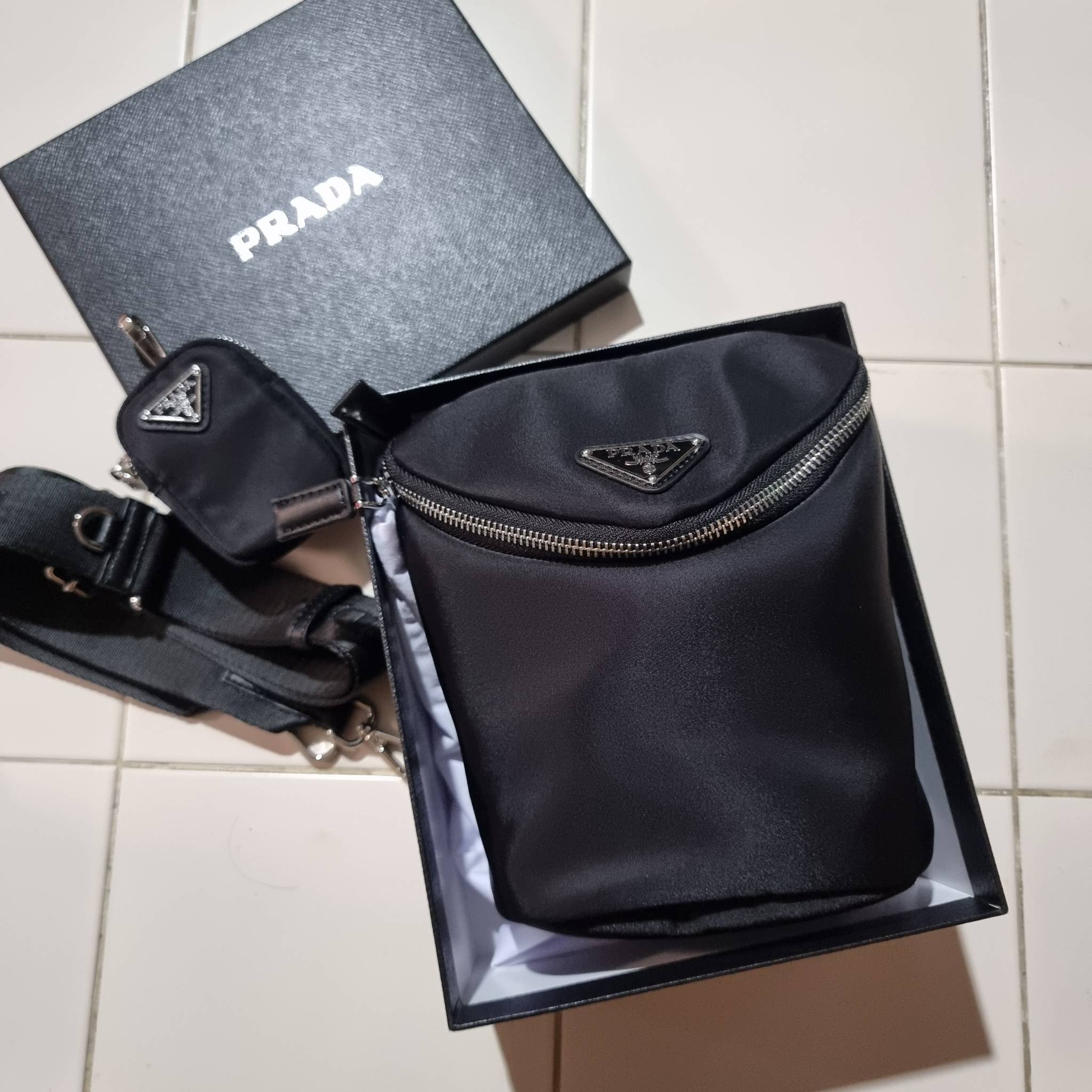 PRADA RE-NYLON AND LEATHER SHOULDER BAG ถึงเวลาของหนุ่มกันแล้ว!! ไอเท็ม best seller ที่เตรียมขึ้นแท่นรุ่นหายาก เท่ คูล ดูดี ไม่เกร่อ กระเป๋าสะพายข้าง รูปทรงเรขาคณิต ดีไซน์เรียบง่าย แต่มีความหรูในตัว วัสดุผ้าไนล่อนคุณภาพ พร้อมใบลูก ไว้ใส่เหรียญ ใส่กุญแจได้