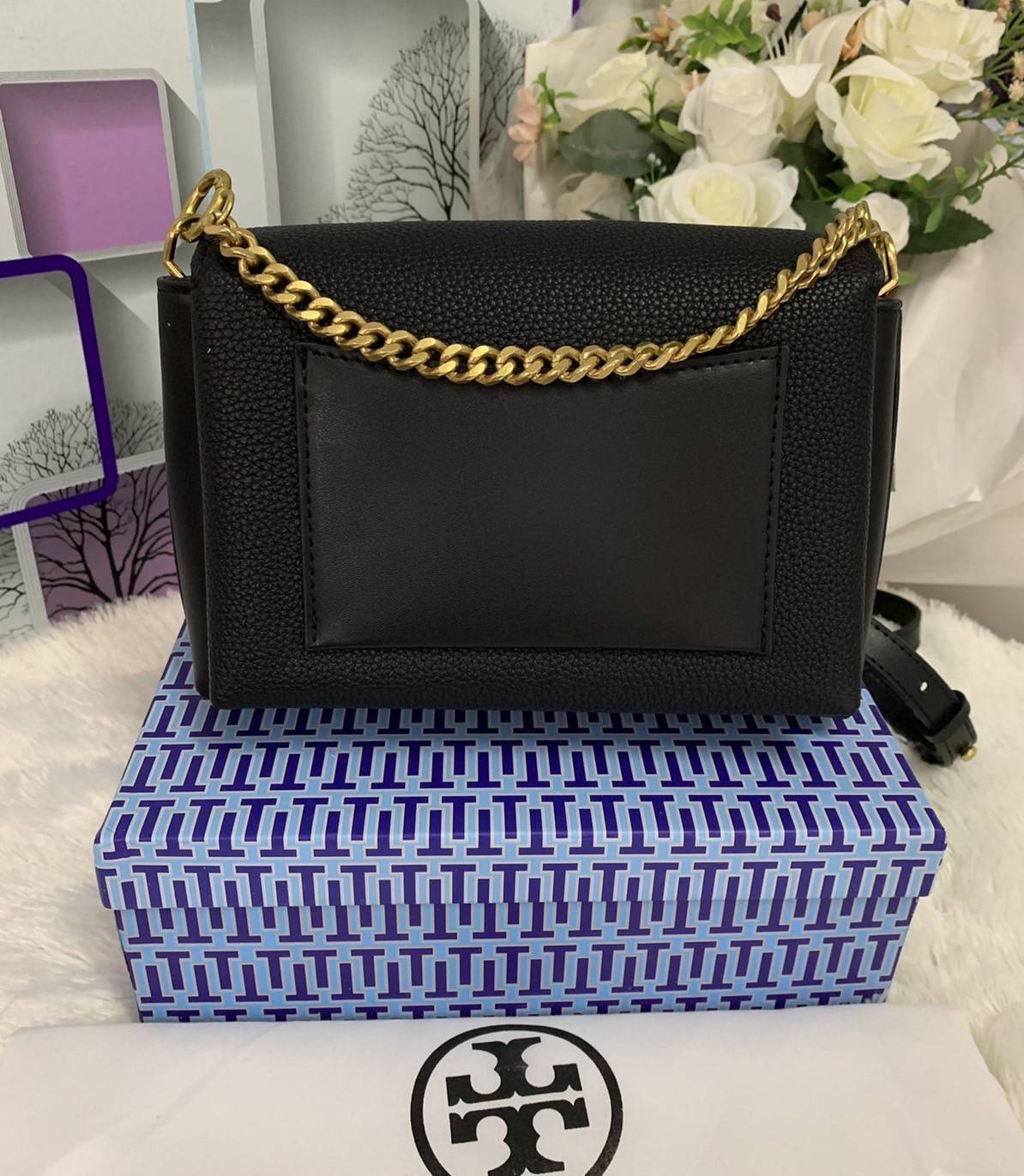 TORY BURCH KIRA MIXED-MATERIALS TOP-HANDLE SATCHEL กระเป๋าสะพายข้าง วัสดุหนังแกะสังเคราะห์ อะไหล่ทอง ด้านหน้าประดับโลโก้แบรนด์ ตกแต่งสายโซ่ห้อยสีทอง (สามารถถอดออกได้) เปิด-ปิดด้วยตัวล็อคหมุน ภายในโล่งกว้าง ซับในบุผ้าลายแบรนด์ แบ่งออกเป็น 3 ช่องใหญ่ พร้อมช