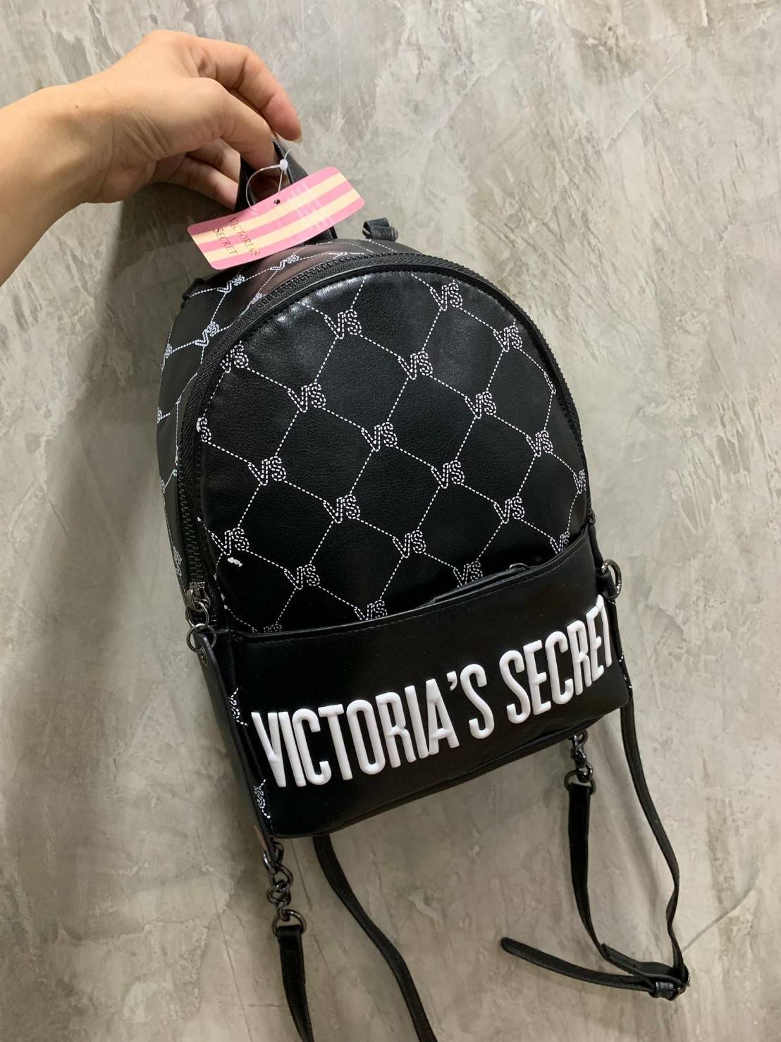 VICTORIA'S SECRET Monogram Mini Citypack กระเป๋าเป้รุ่นใหม่ ดีไซน์สวยเรียบหรู วัสดุหนังเรียบลาย Monogram Cool ขนาดกลางกำลังดี ใส่มินิไอแพค กระเป๋าสตางค์ยาวได้ น้ำหนักเบา เปิดปิดด้วยซิปเดียวหางซิปยาวสกรีนโลโก้แบรนด์ สายสะพายโซ่ต่อหนังแบบเข็มขัดปรับระด
