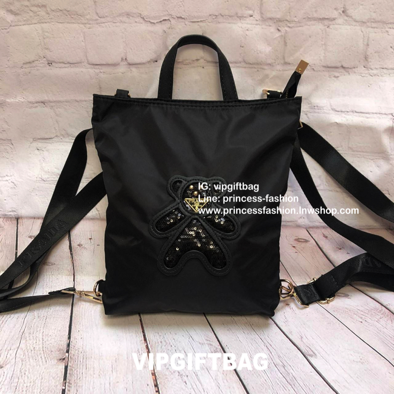 กระเป๋าสะพาย ทรง TOTE จากแบรนด์ PRADA มาค่า ตัวกระเป๋าเป็น nylon ทั้งใบ สะพายเป็น shoulder bag หรือถือได้ค่ะหรือสะพายเป็นเป้ก้ยังได้ ด้านหน้าเป็นลายหมี ปักกลิ้ตเตอร์ + logo brand ใช้แล้วสวยมากๆ อะไหล่ทองหรูมาก จุของคุ้ม ใส่หนังสือหรือของจุกจิกก็ไ้ด้หมด สว