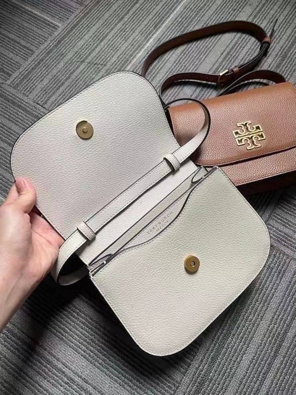 TORY BURCH BRLTTEN SMALL SADDLE BAG / Tory Burch Britten Flap Shoulder Bag กระเป๋าสะพายข้าง วัสดุหนังแกะแท้ ด้านหน้าประดับโลโก้แบรนด์ เปิด-ปิดกระเป๋าแบบกระดุมแป็กแม่เหล็กแน่นหนา ภายในมีช่องหลัก ใส่กระเป๋าเงินใบกลาง มือถือได้ทุกรุ่น มีช่องแยกใส่ของจุกจิกอี