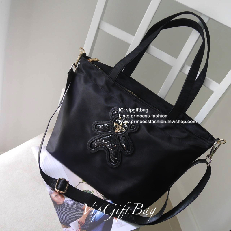 เอาใจคนชอบกระเป๋าไซส์กลาง *มาพร้อมสายยาว สำหรับกระเป๋าอเนกประสงค์ ทรง TOTE จากแบรนด์ PRADA เป็น กระเป๋าผ้าไนล่อน ตามแบบฉบับของแบรนด์เลย ใบนี้มีสายยาวให้ค่ะ เลิศมาก สะพายเป็น shoulder bag หรือ ถือได้คะ ด้านหน้าเป็นลายหมี ปั๊กกลิ้ตเตอร์ + logo brand ใช้แล้ว