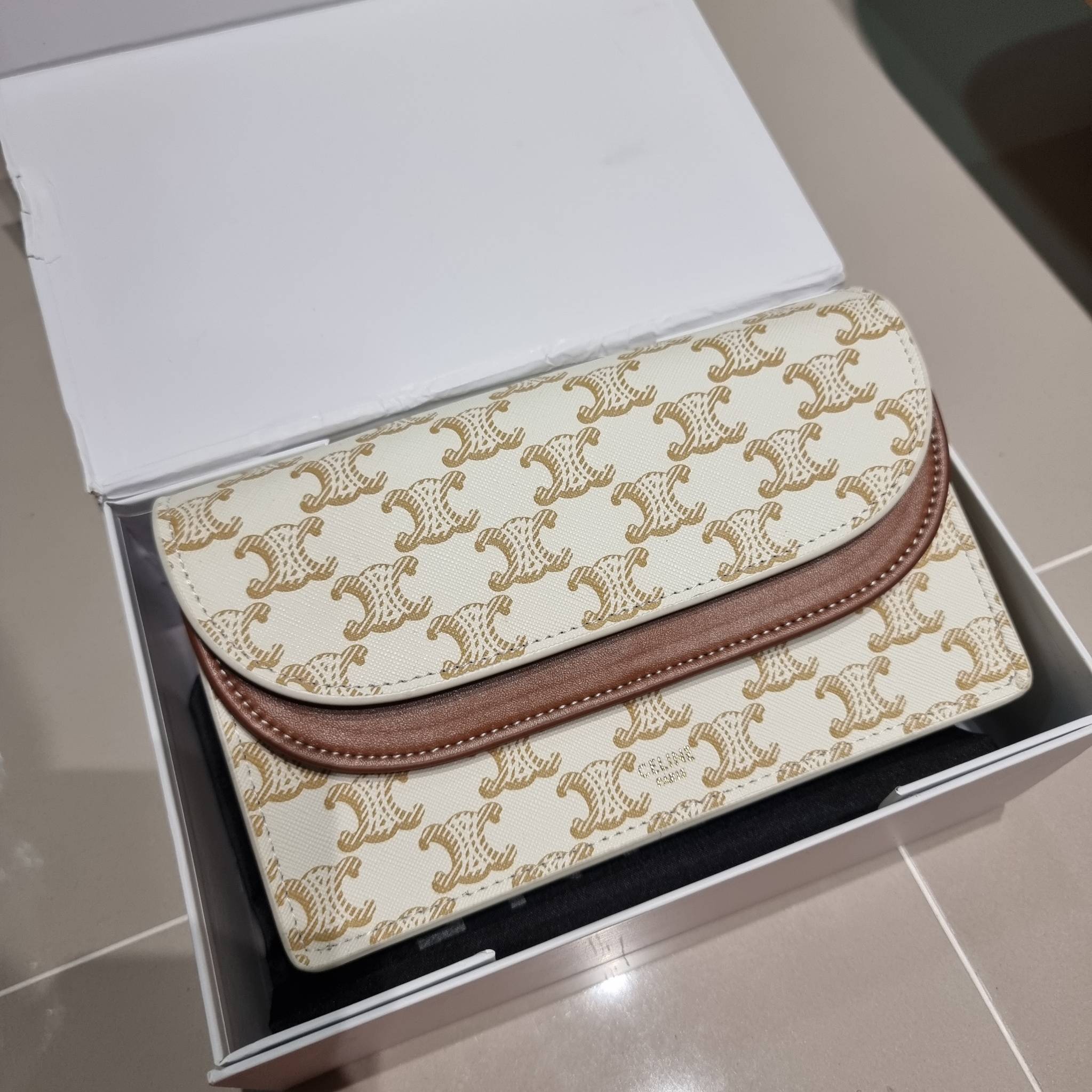 CELINE WALLET ON STRAP IN TRIOMPHE CANVAS AND LEATHER อีกหนึ่งรุ่นยอดนิยม กระเป๋าสะพายกึ่งคลัทช์ ในรูปแบบกระเป๋าสตางค์ ให้พกพาได้ง่าย ใส่ของสำคัญ มือถือ หรือบัตรต่างๆได้