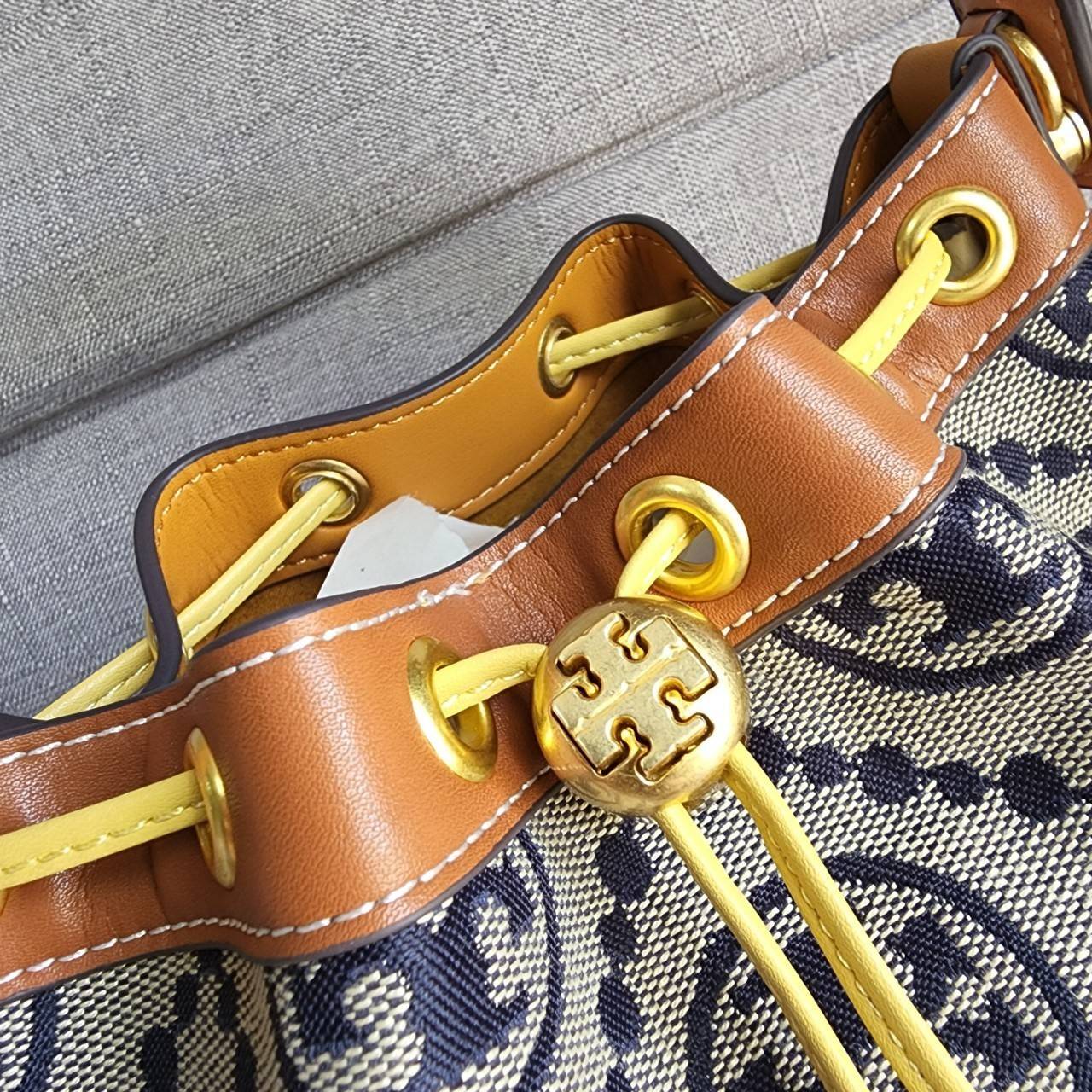 Tory Burch T Monogram Colorblock Bucket Bag กระเป๋าสะพาย ทรงบัคเกต รุ่นฮอต สไตล์ไหนเข้าได้ทุกลุค วัสดุ jacquard ตัดขอบหนังแท้ ภายในเป็นช่องโล่งกว้าง ใส่ของได้เยอะหยิบจับสะดวก มาพร้อมสายสะพายข้างหนังแท้ ถอดและปรับระดับได้สะพายชิวได้ทุกโอกาส