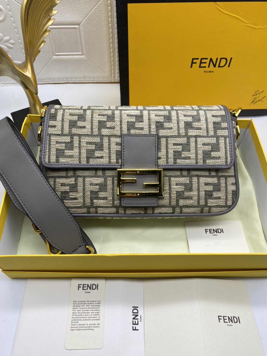 Fendi Baguette FF Tapestry Fabric Bag เกรดออริจินอล กระเป๋าทรง Baguette ขนาดกลาง วัสดุผ้าเซนิล พร้อมลวดลาย FF สีเทาเข้ม ปิดท้ายด้วยรายละเอียดหนังแบบทูโทนและประดับด้วยตัวล็อค FF โดดเด่นด้วยฝาปิดด้านหน้าตัวล็อคแม่เหล็กช่องด้านในบุด้วยผ้าหนังกลับพร้อมกระเป๋า