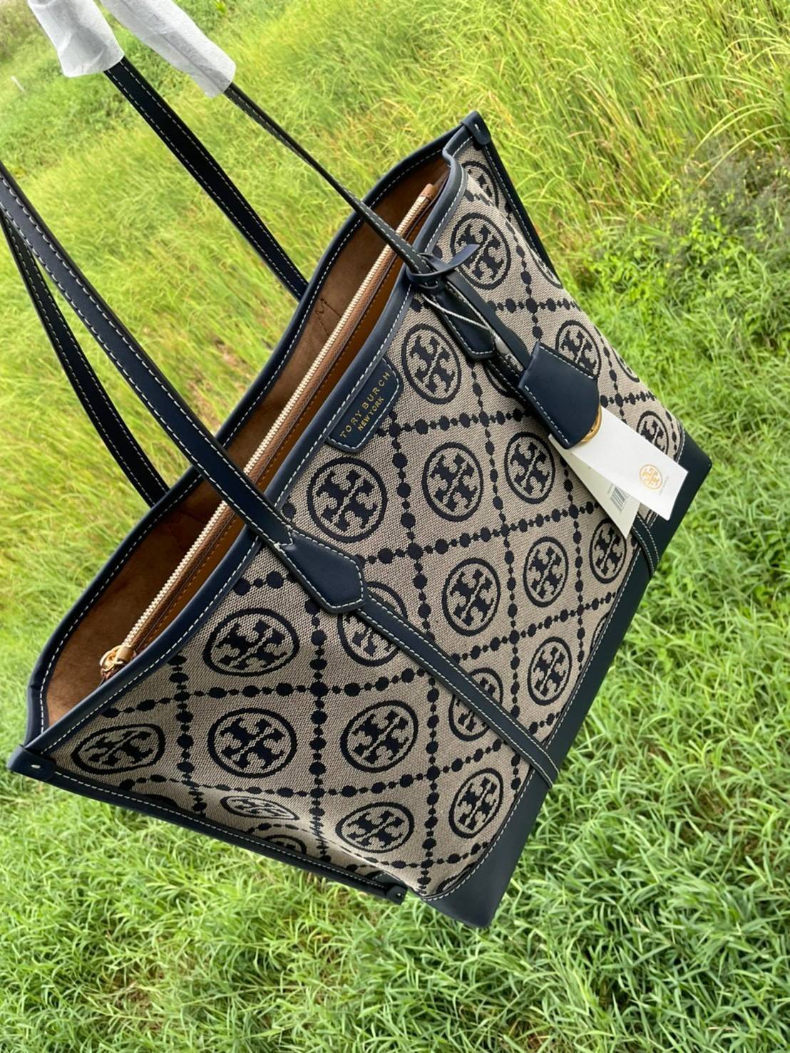 TORY BURCH T MONOGRAM TRIPLE - COMPARTMENT TOTE กระเป๋า/สะพายไหล่ทรง SHOPPING BAG วัสดุผ้าผ้าแคสวาสปักลายสัญลักษณ์แบรนด์ ตั้งอยู่ทรง สวยหรู ดูแพง จุของได้เยอะมาก ภายในแยกเป็น 2 ช่องหลัก 1 ช่องซิปตรงกลาง แบ่งเป็นสัดส่วนใช้งาน