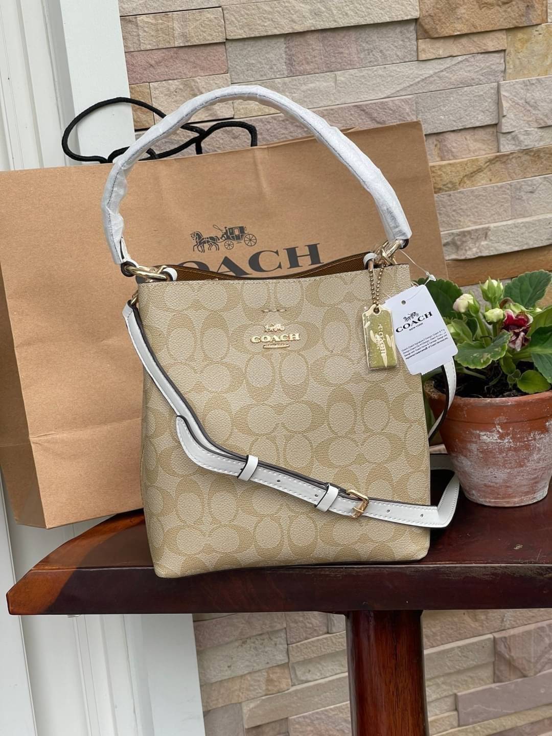 COACH SMALL TOWN BUCKET BAG IN SIGNATURE สำหรับสาวแฟชั่นที่ชอบรายละเอียดชิคๆ ดีไซน์สุดเก๋ แนะนำเลยสำหรับกระเป๋าทรงบักเก็ตใบนี้ เชื่อว่าสาว ๆ หลายคนชื่นชอบ เป็นไอเทมที่สามารถแมทช์ได้กับเสื้อหลากหลายสไตล์ บรรจุของได้เยอะโดยที่กระเป๋าไม่เสียทรง แบ่งช่องใช้งา