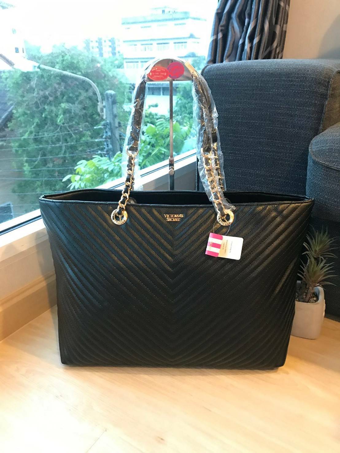 Victoria’s Secret Quileted Tote Bag กระเป๋าถือหรือสะพายลายหนังแกะสังเคราะห์อยู่ทรงสวย ดีไซน์ลายริ้วเป็นตัววี ด้านหน้าประดับด้วยโลโก้อะไหล่ทอง เปิดปิดด้วยซิปเดียว ภายในมีช่องโล่งและช่องเล็กไว้แบ่งเก็บของ ใส่หนังสือ เอกสาร A4 Notebook ipad กระเป๋าสตางค์ ของ